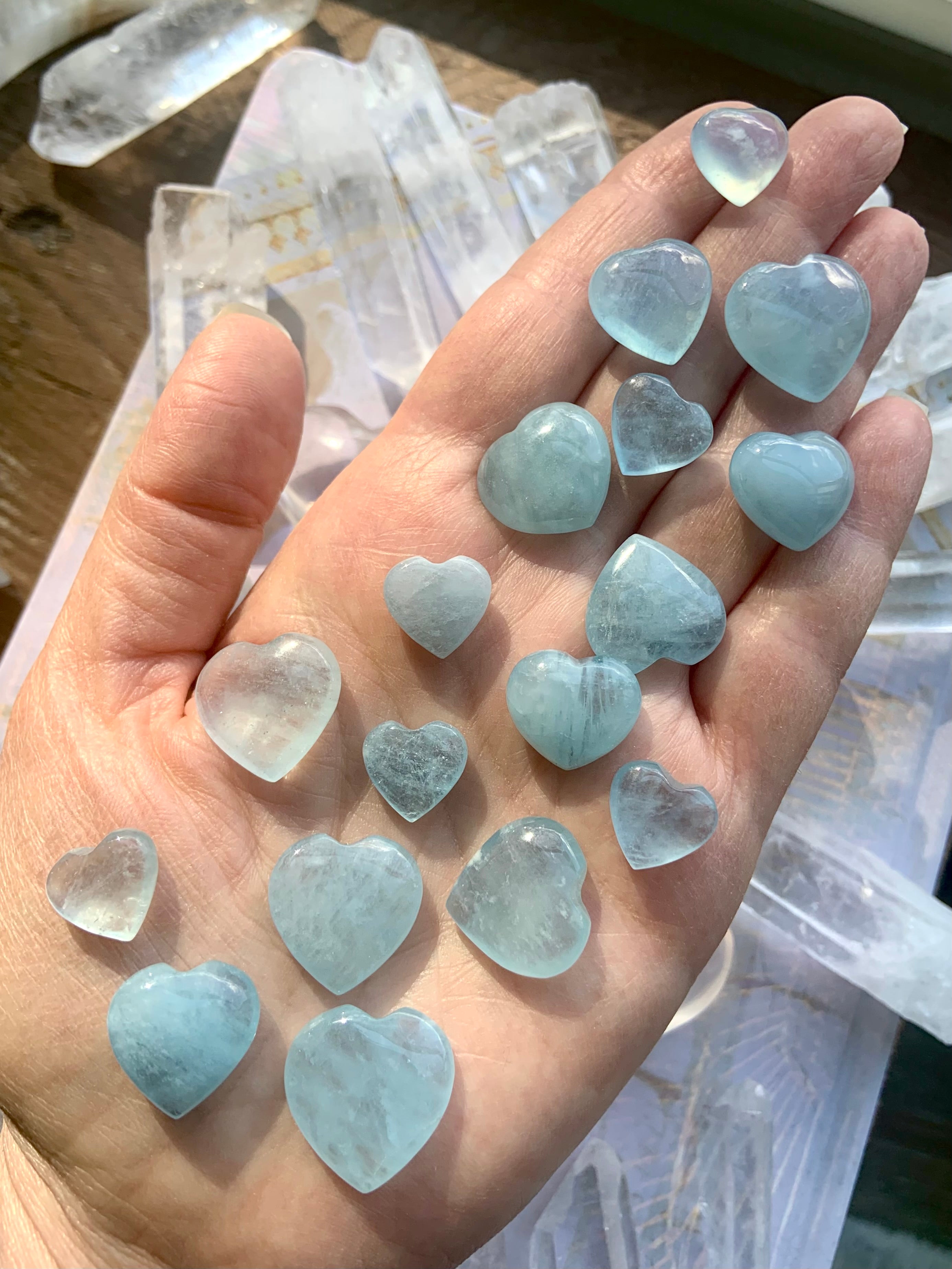 Closeup of Aquamarine hearts on a hand — peaceful mini heart carvings for calming anxiety + supporting authentic self-expression.