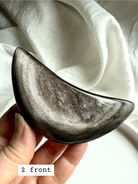Polished Silver Sheen Obsidian crescent moon in hand, grounding protection stone for self-reflection and clarity