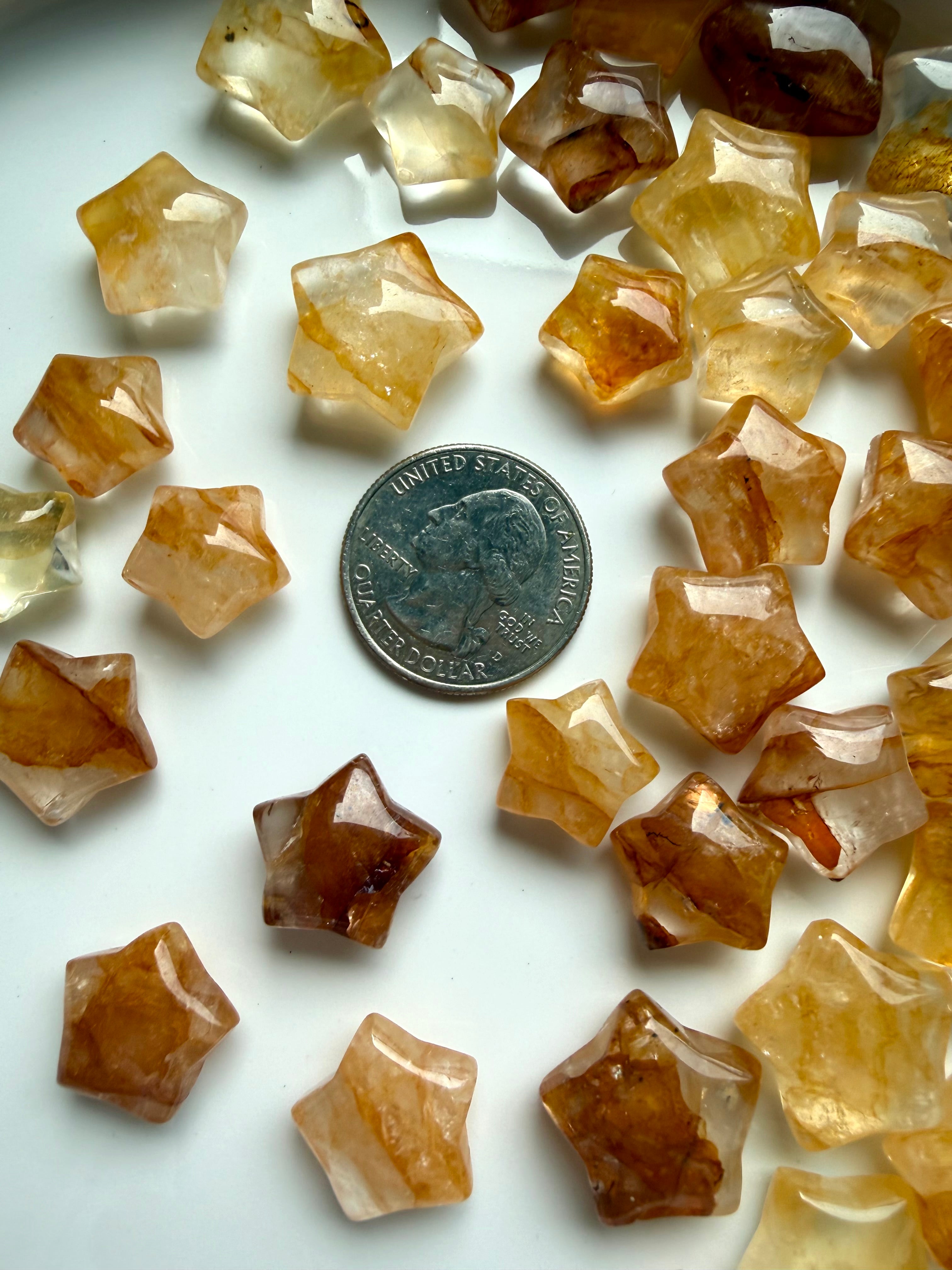 Golden Healer Quartz mini stars showing translucent quartz with rich golden Hematoid mineral inclusions shown with a US quarter for scale