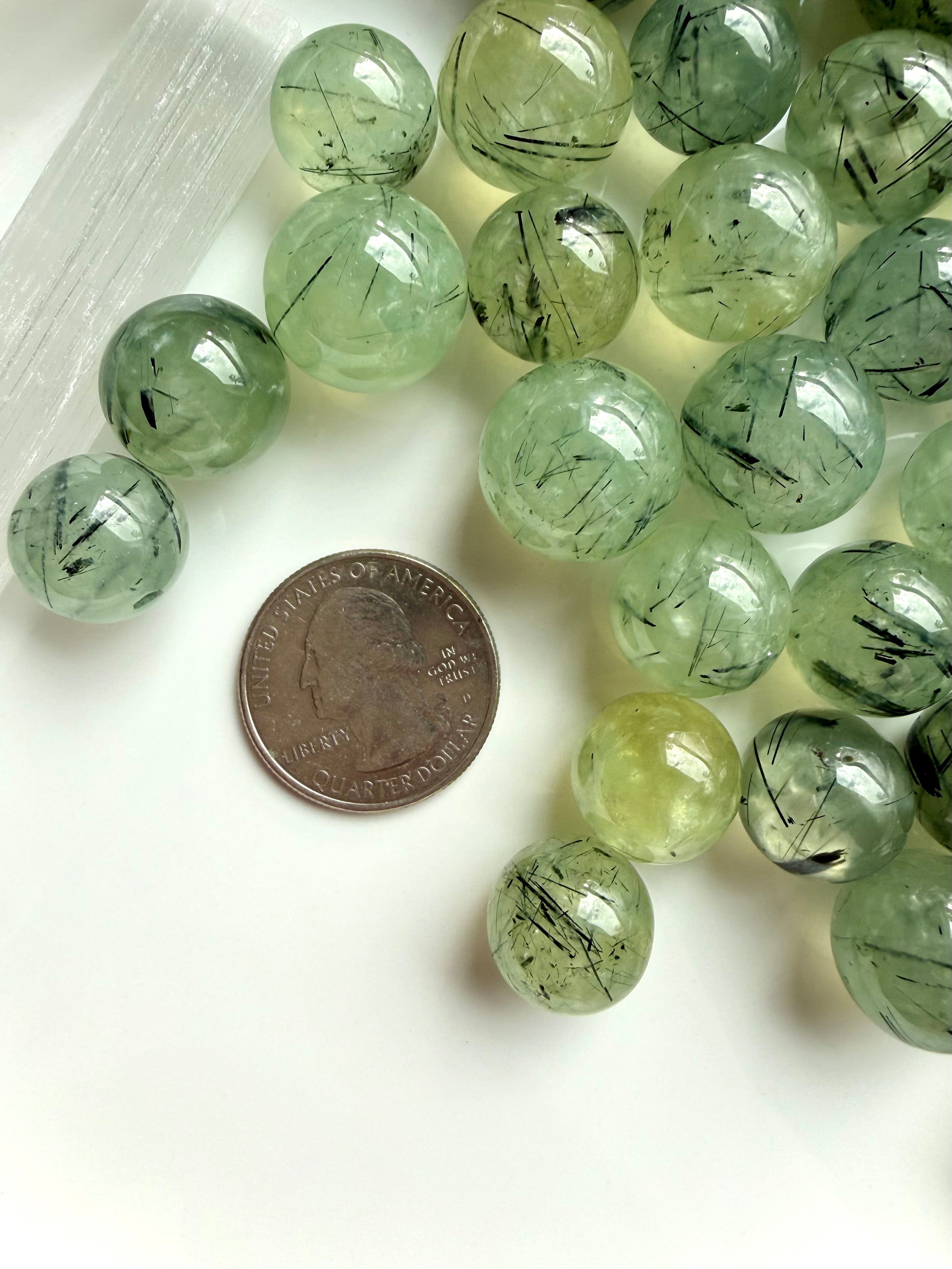 prehnite mini spheres with coin for scale showing small size and translucent green color