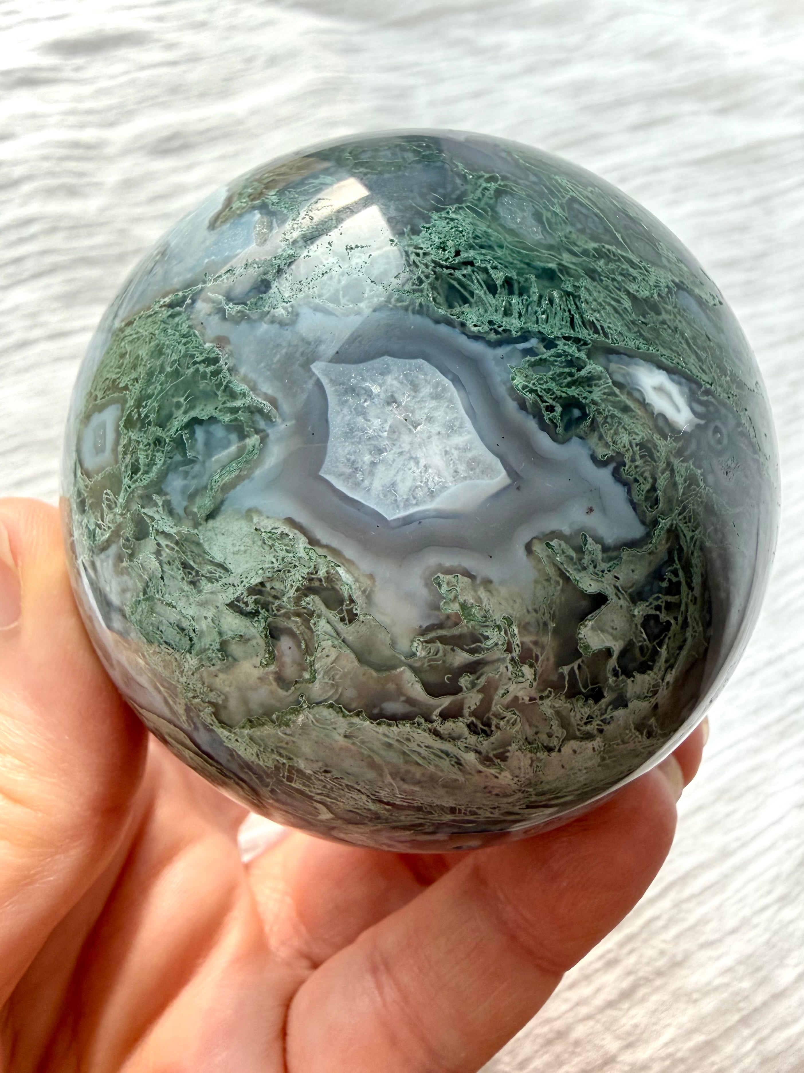 Polished Moss Agate sphere with intricate botanical dendrites and layered gray chalcedony
