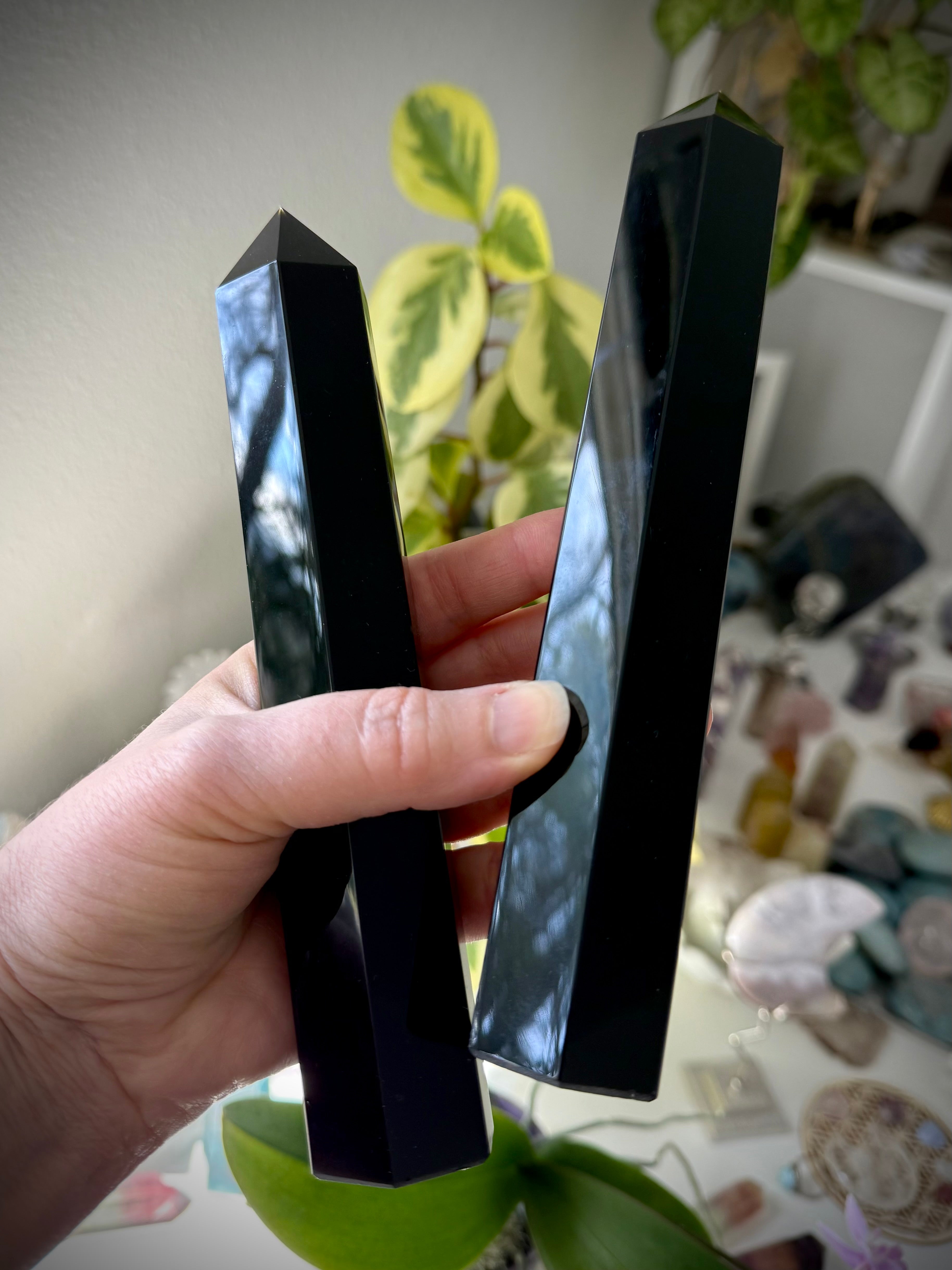 Two large Black Obsidian towers held in hand — reflective crystals for shielding & grounding.