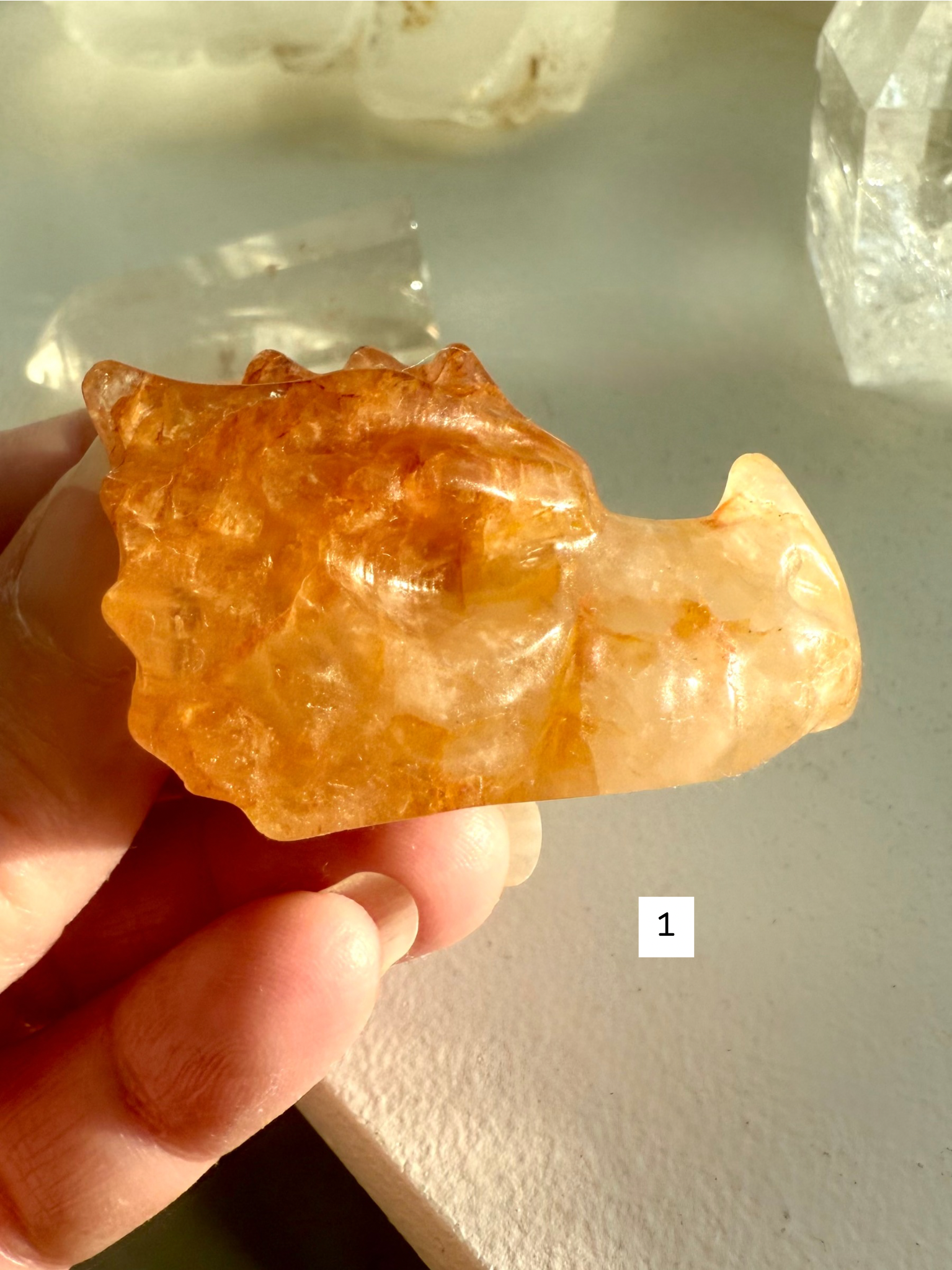 Golden Healer Quartz dragon head carving held in hand — crystal figurine with golden hematite inclusions for chakra healing and energy work.