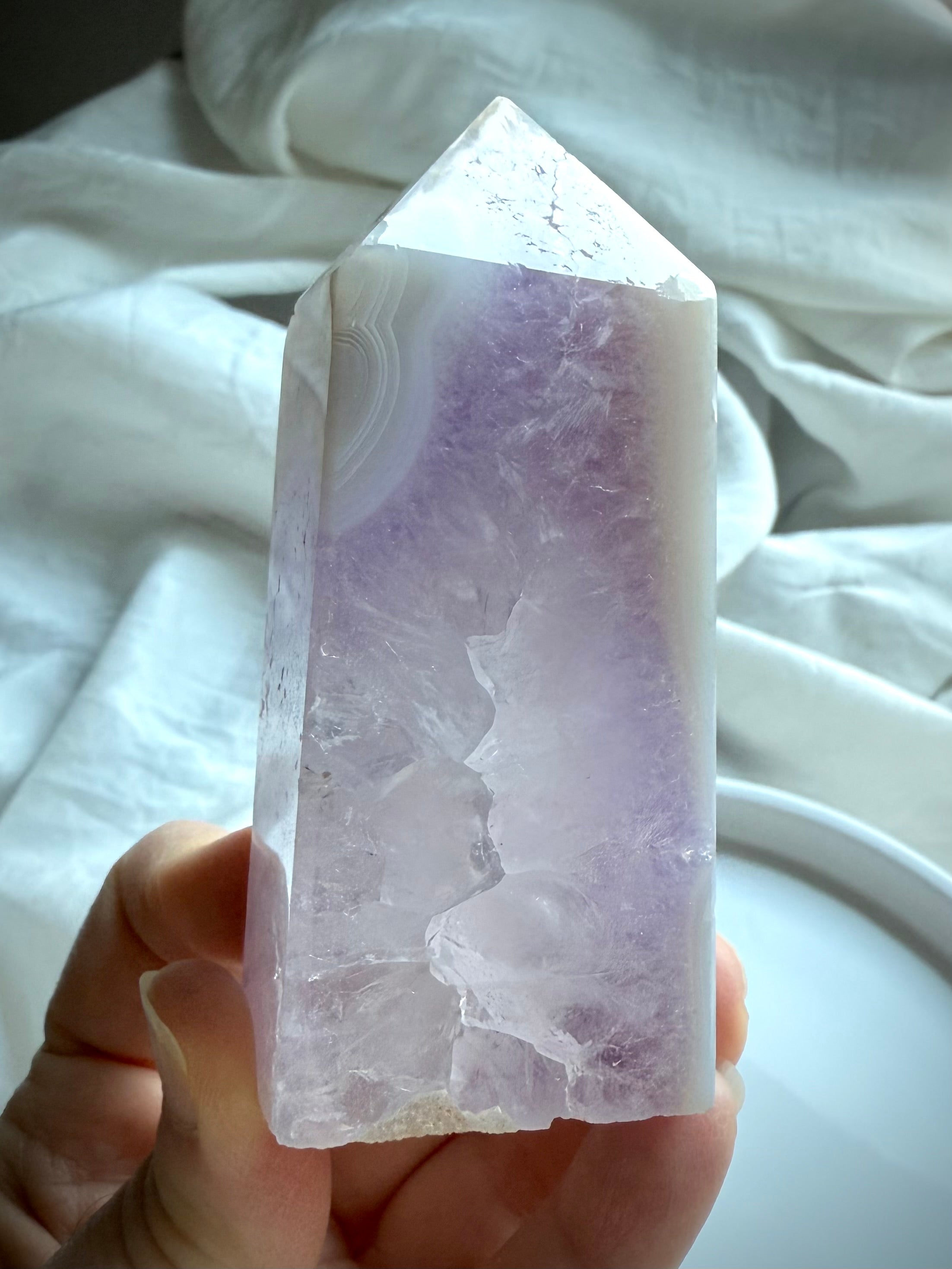 Hand holding Amethyst Geode Tower with lavender core and banded agate tip