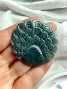 Back view of a Blue Water Jade peacock carving with detailed feather pattern and polished finish
