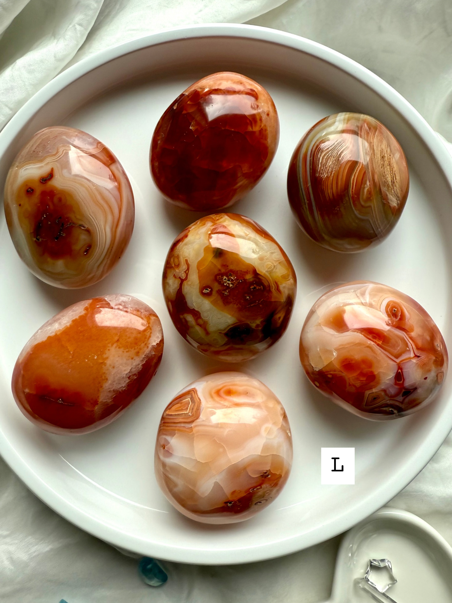 Large Carnelian palm stone with layered red-orange banding — powerful crystal for strength, passion + inner fire