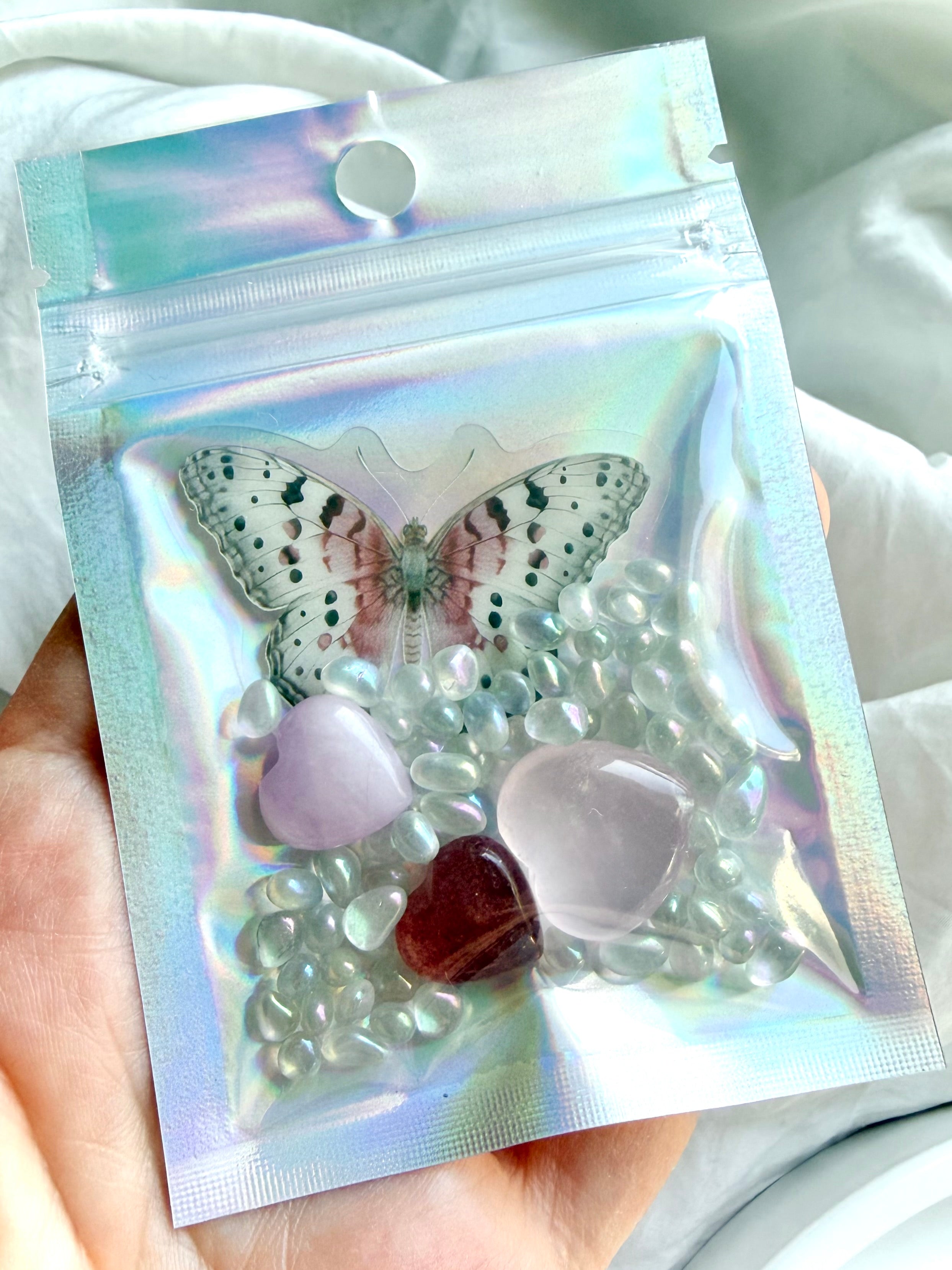 Mini crystal heart trio gift set in iridescent pouch with butterfly sticker, rose quartz, strawberry quartz, kunzite, and aura crystal confetti