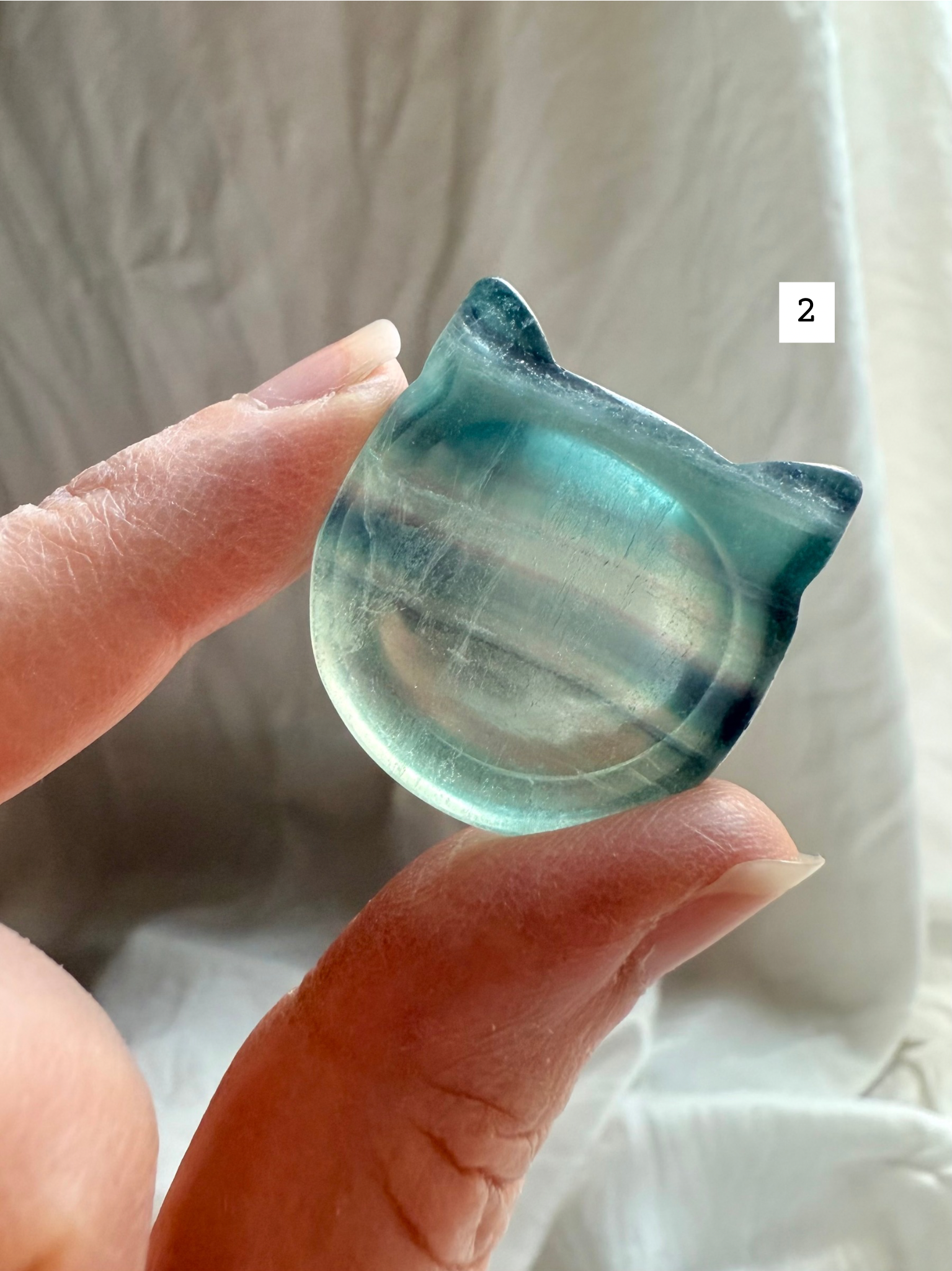 Fluorite cat-shaped crystal bowl held to the light – mini ring dish and jewelry holder