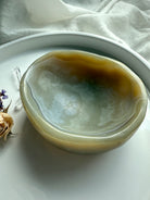 Top view of polished beige agate bowl with earthy banding – crystal dish for grounding and balance
