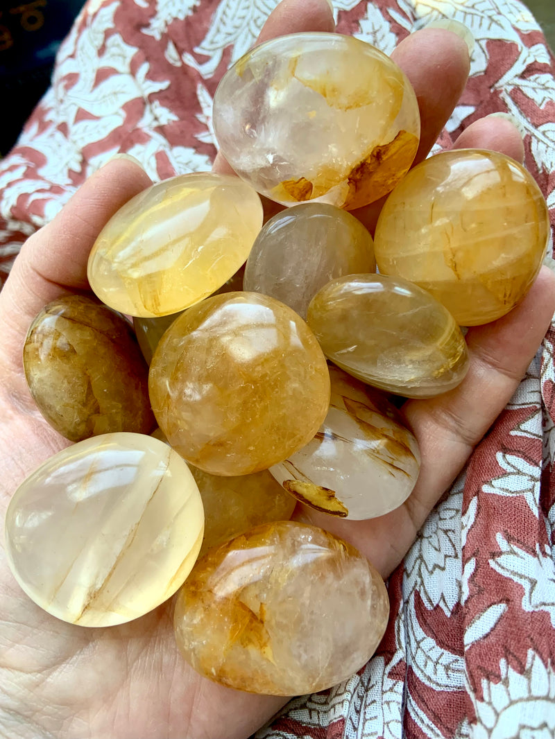 Small Golden Healer Quartz Palm stones shown in indirect natural light on my hand. Hold one of these special stones in meditation for Solar Plexus Chakra Healing