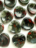 top view of bloodstone hearts in bowl with varied red and green patterning, worry stones for strength grounding and resilience