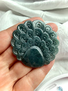 Back view of a Blue Water Jade peacock carving with detailed feather pattern and polished finish