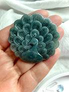 Hand-carved Blue Water Jade peacock medallion showing intricate feather details and soft blue-green tones