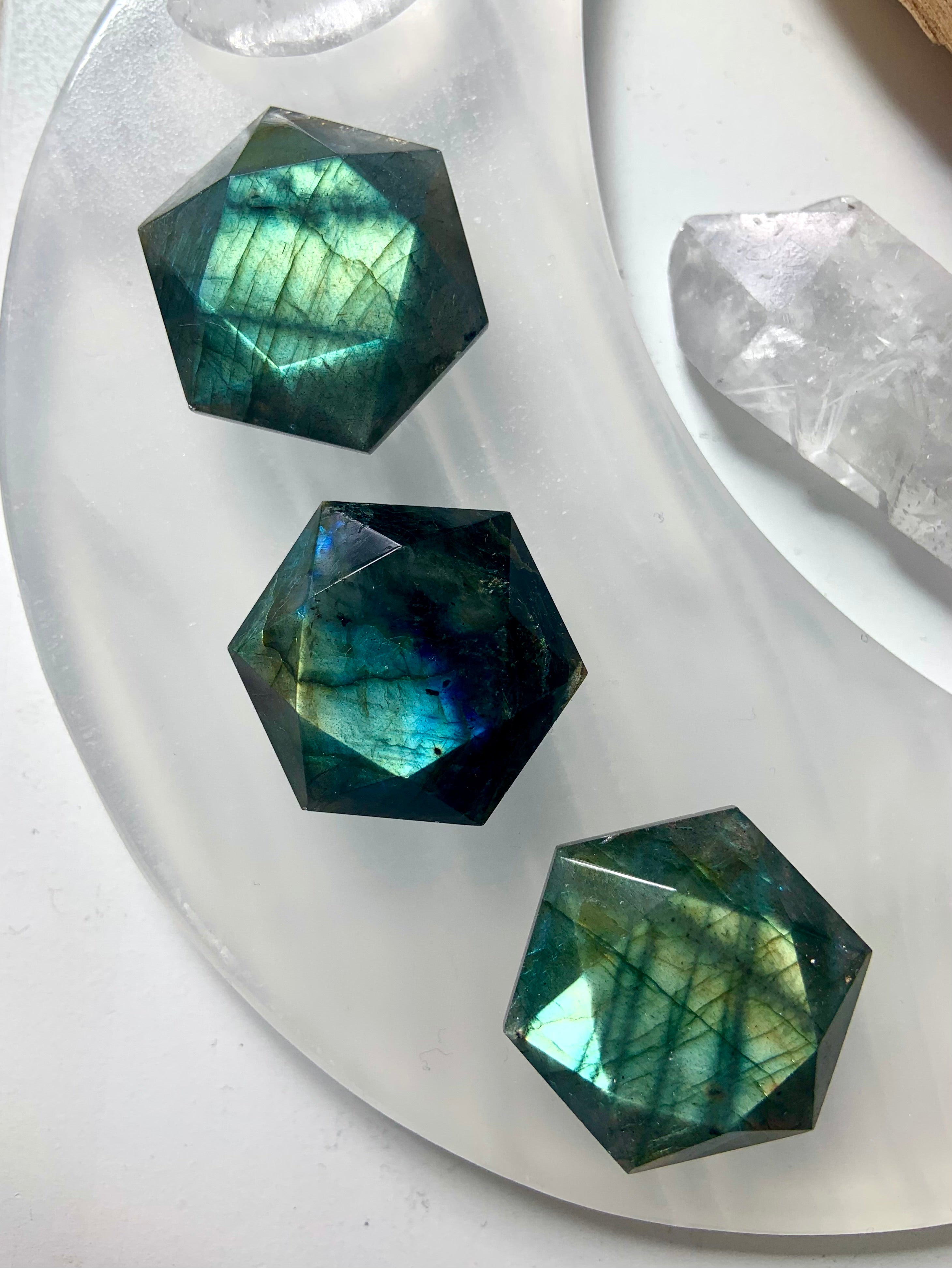 Teal blue Labradorite hexagons on a white moon plate with mini crystal carvings — vibrant Third Eye chakra crystals for intuition & spiritual awakening.