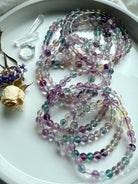 Rainbow fluorite bracelet styled with clear quartz points and dried flowers for a calming crystal aesthetic