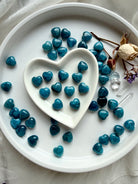 Mini Blue Apatite hearts displayed in white ceramic heart dish, polished crystal hearts for emotional clarity and sacred gifting
