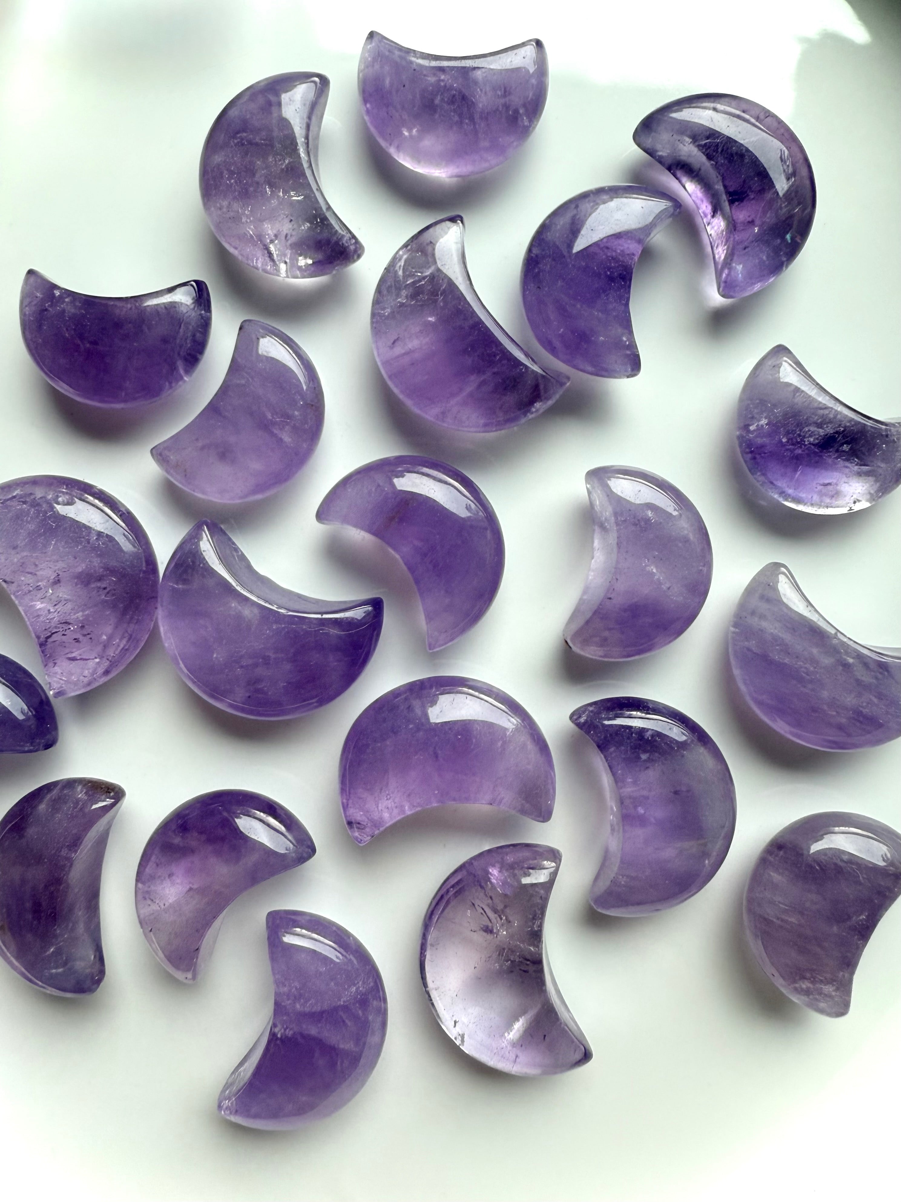 Polished amethyst crescent moons showing natural lavender to deep purple color variation