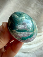Deep teal Ocean Jasper palm stone with soft lavender-gray banding and natural landscape-like mineral formations