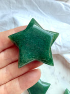 Green Aventurine star carving held in hand, a polished Heart Chakra crystal for abundance, growth, and new beginnings