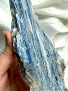 Close up of raw blue kyanite with muscovite mica showing natural flaky crystal texture and silvery shimmer