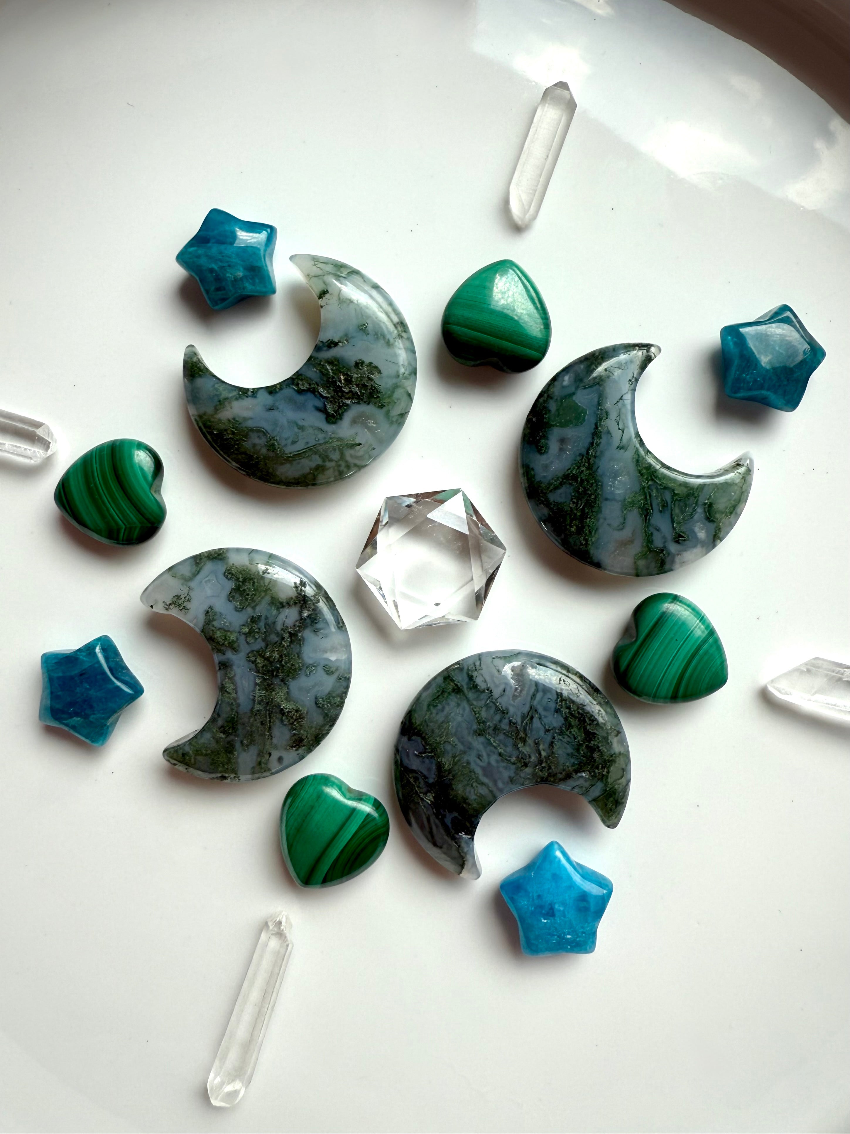 Nature-inspired crystal grid with Moss Agate moons, Apatite stars, Malachite hearts, and Quartz points around a Clear Quartz hexagon centerpiece.