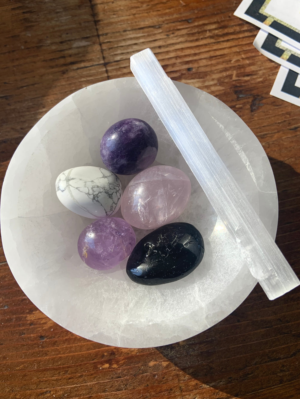 White Selenite bowl filled with tumbled stones and selenite stick — cleansing tool for energetic protection