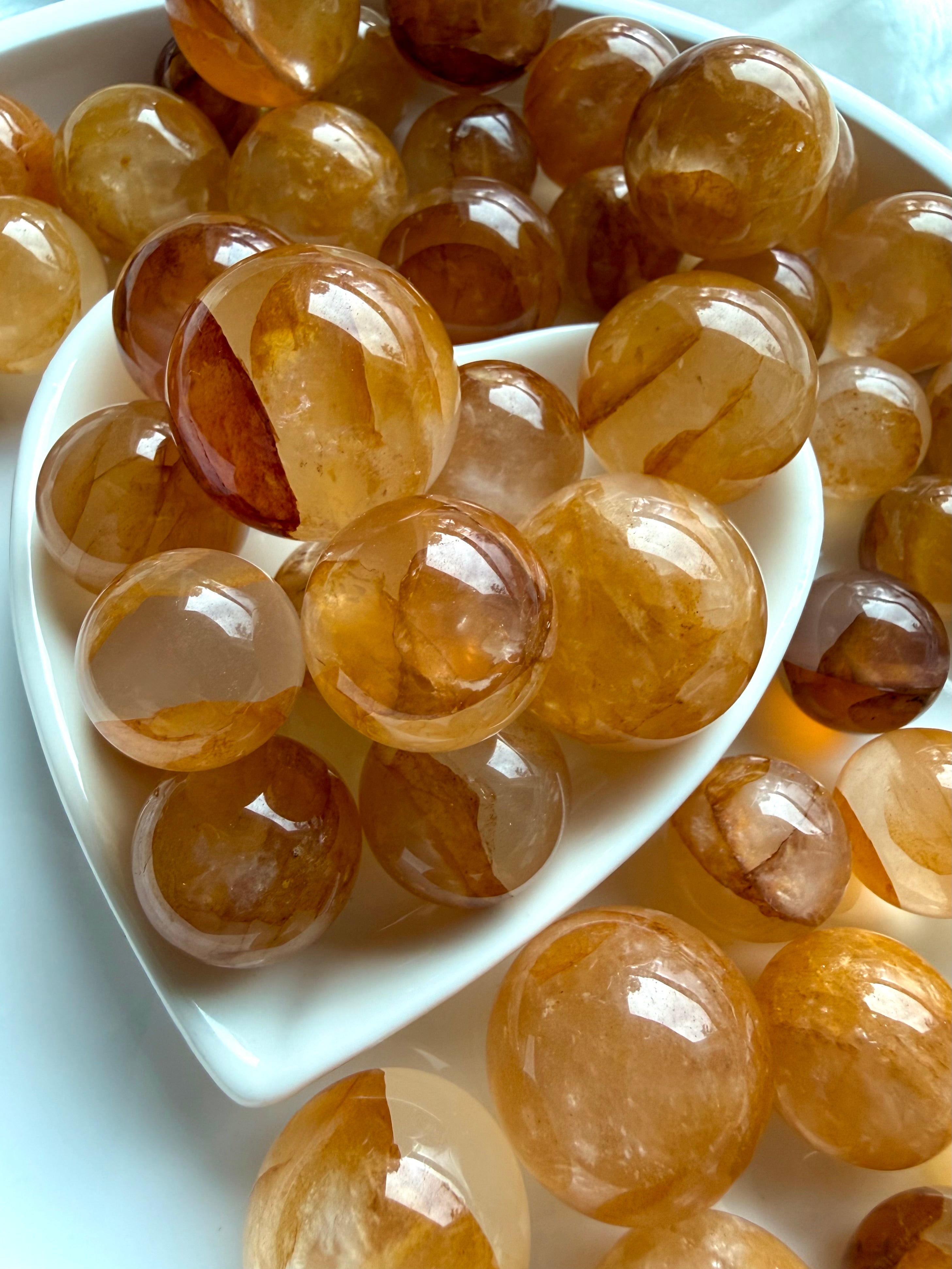 collection of golden healer quartz mini spheres with blended amber tones and internal veiling