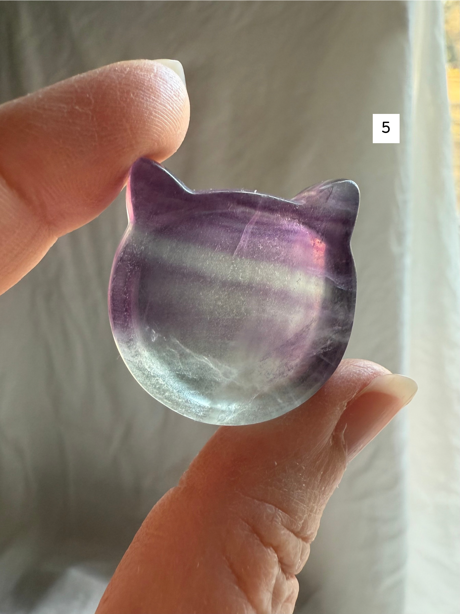 Fluorite cat-shaped crystal bowl held to the light – mini ring dish and jewelry holder