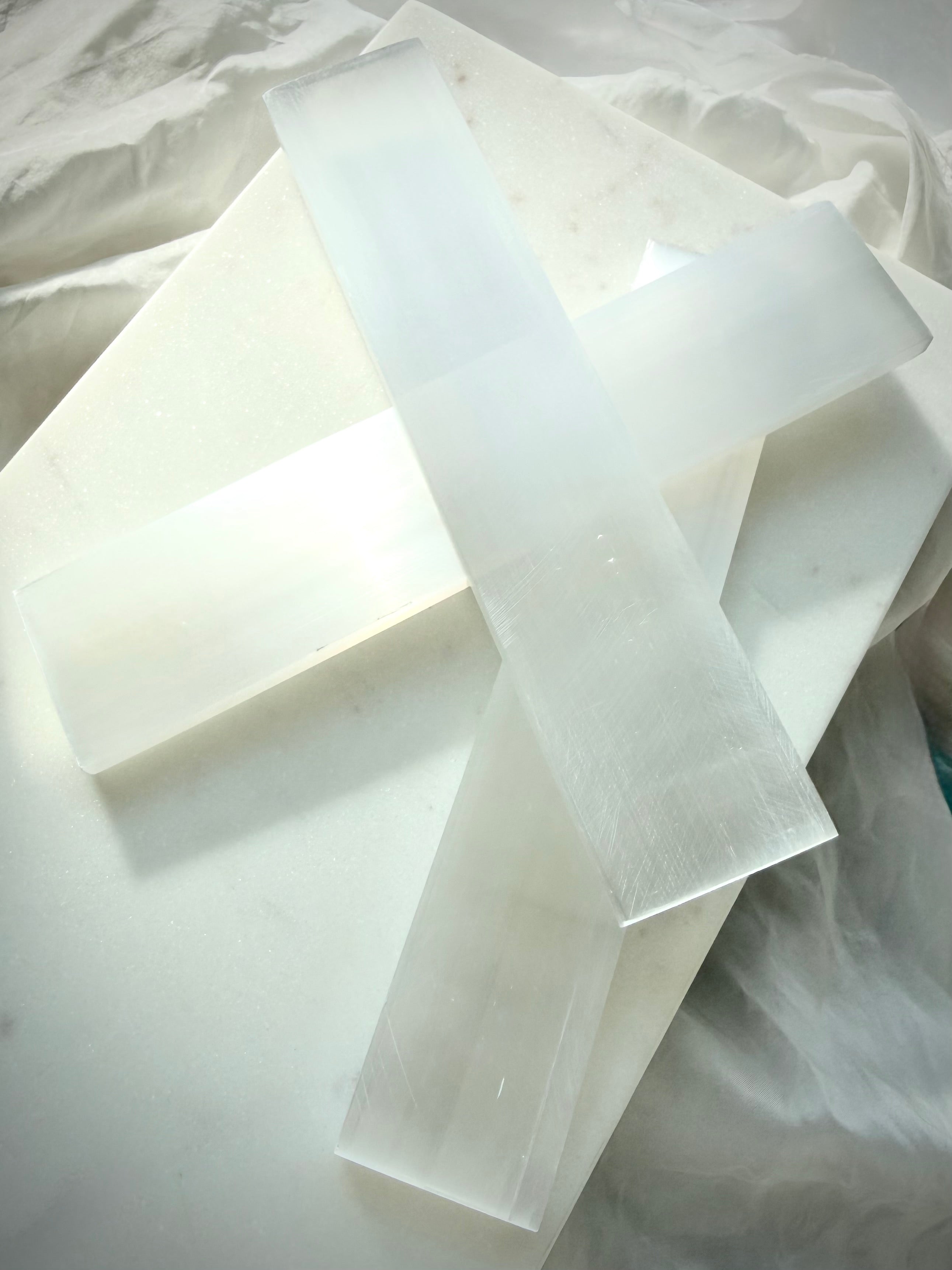 Rectangular Selenite crystal charging bars arranged together, featuring translucent white Satin Spar with natural fibrous banding