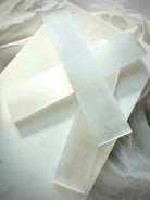 Rectangular Selenite crystal charging bars arranged together, featuring translucent white Satin Spar with natural fibrous banding