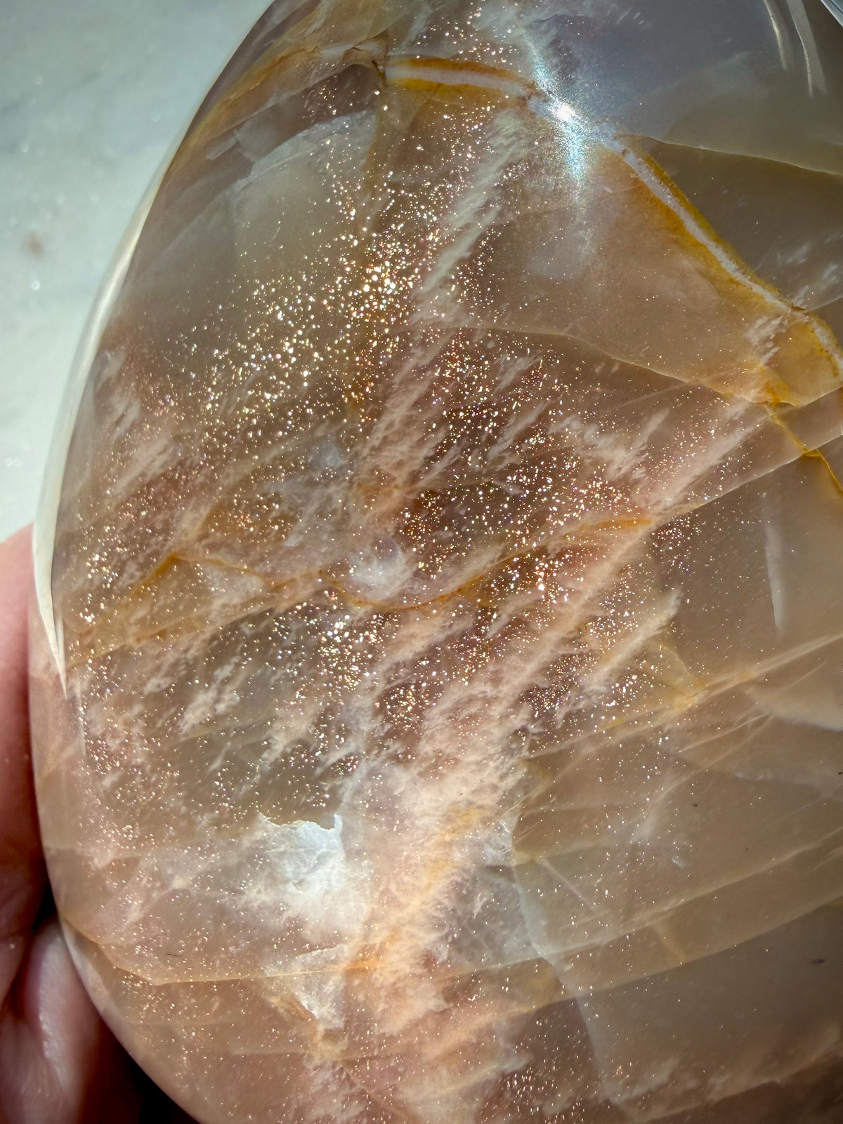 Close-up of Peach Moonstone freeform with sparkling golden Sunstone inclusions and warm orange peach tones