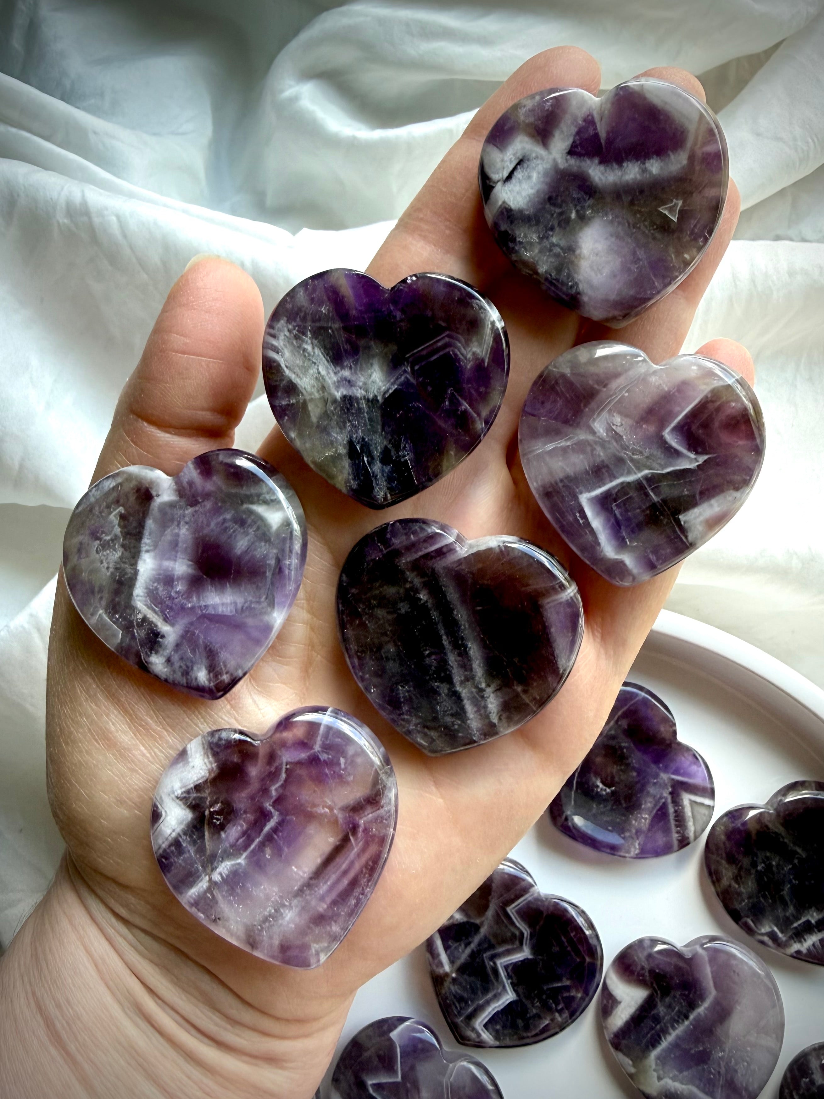 dream amethyst heart worry stones shown on hand with chevron banding for calming energy