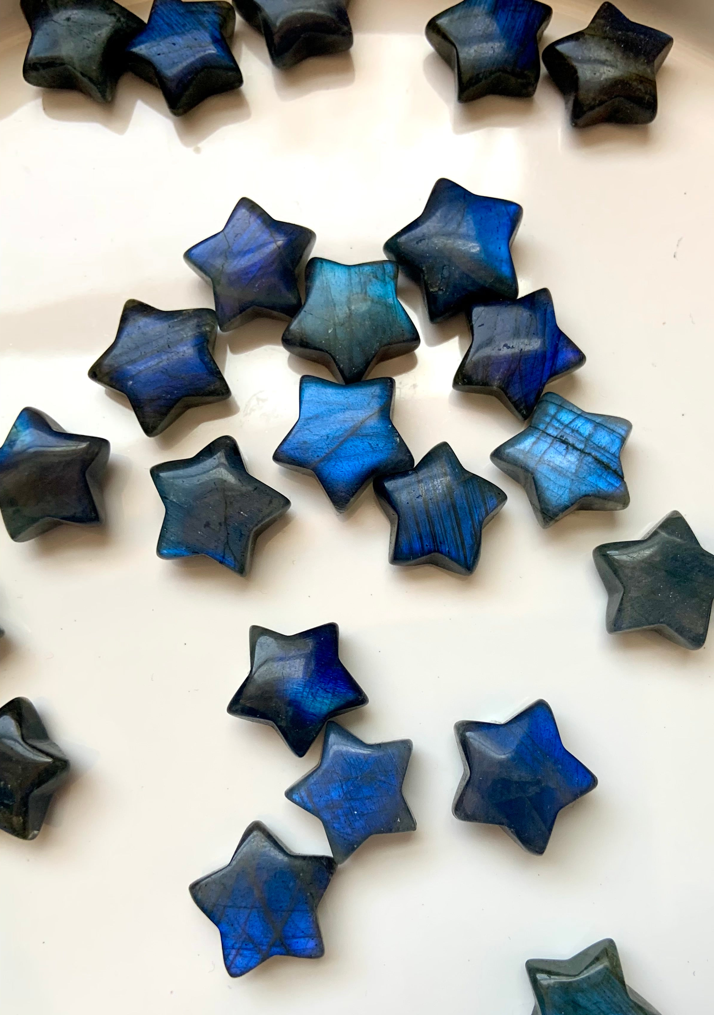 Mini Labradorite star crystals with rich blue flash shown on white background — high-vibe stones for energy shielding &amp; inner guidance.