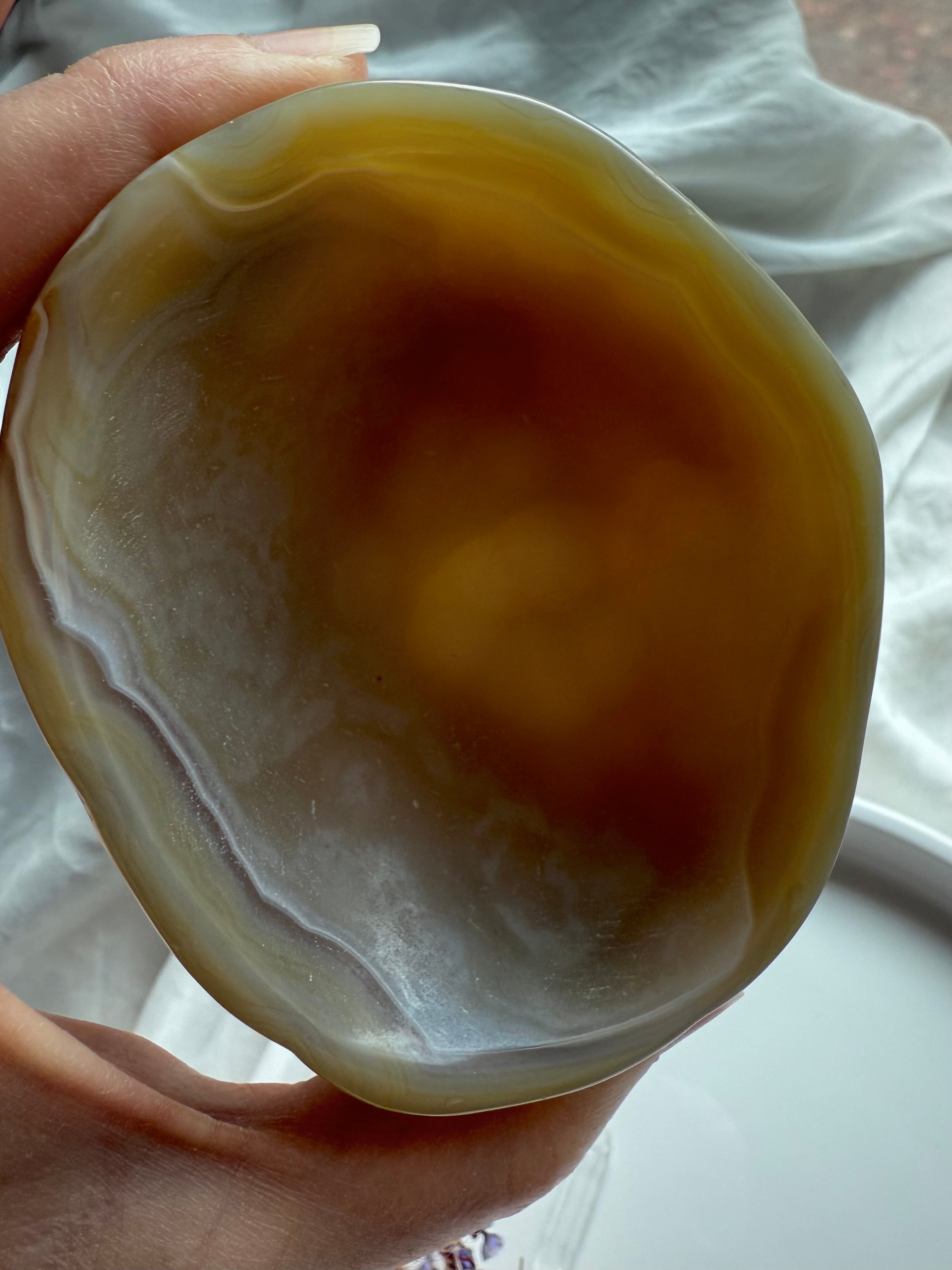 Backlit view of hand-carved Beige Agate bowl – polished gemstone dish for altar décor and balance
