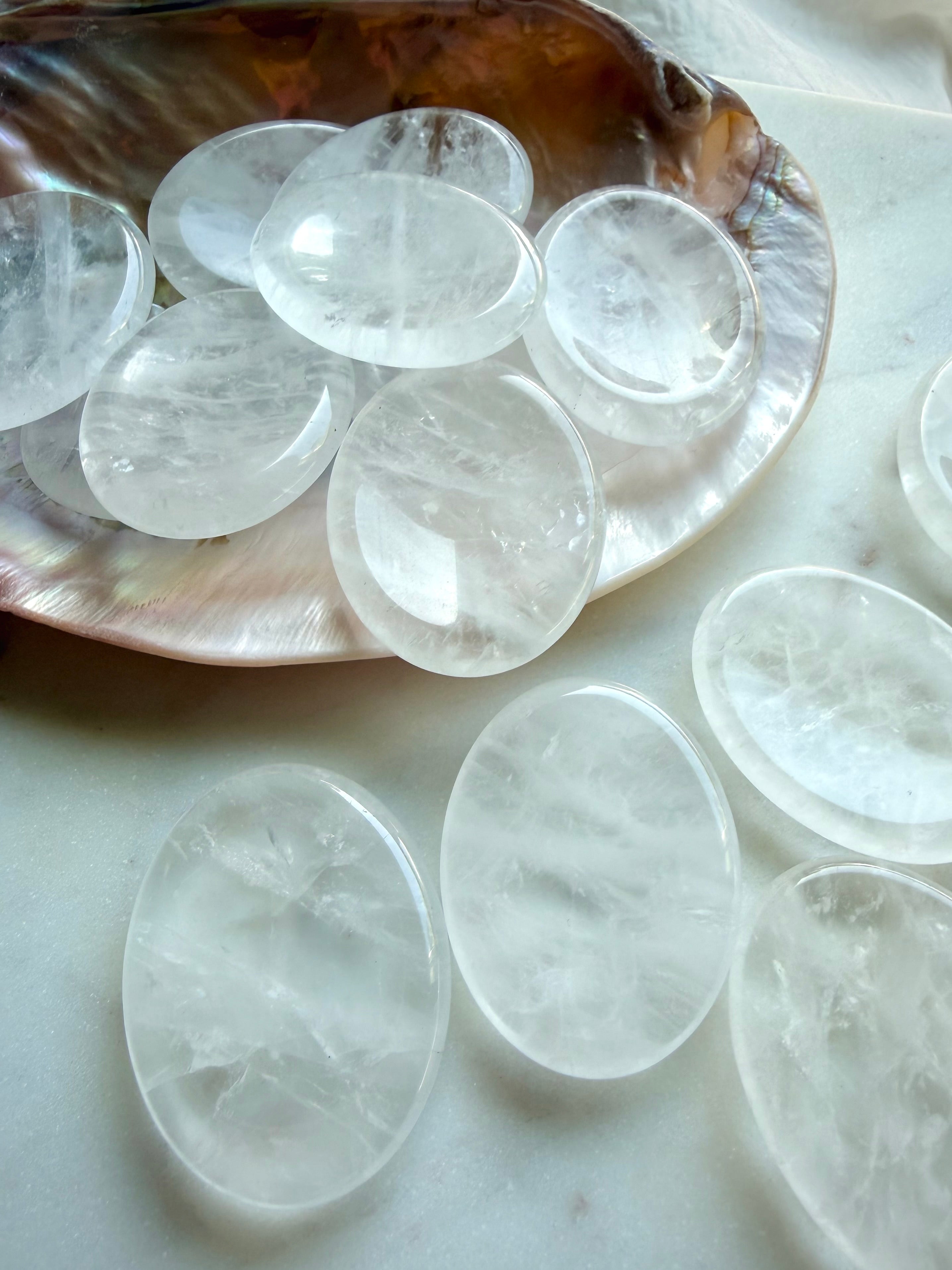 clear quartz worry stones arranged on seashell dish for meditation focus and crystal healing