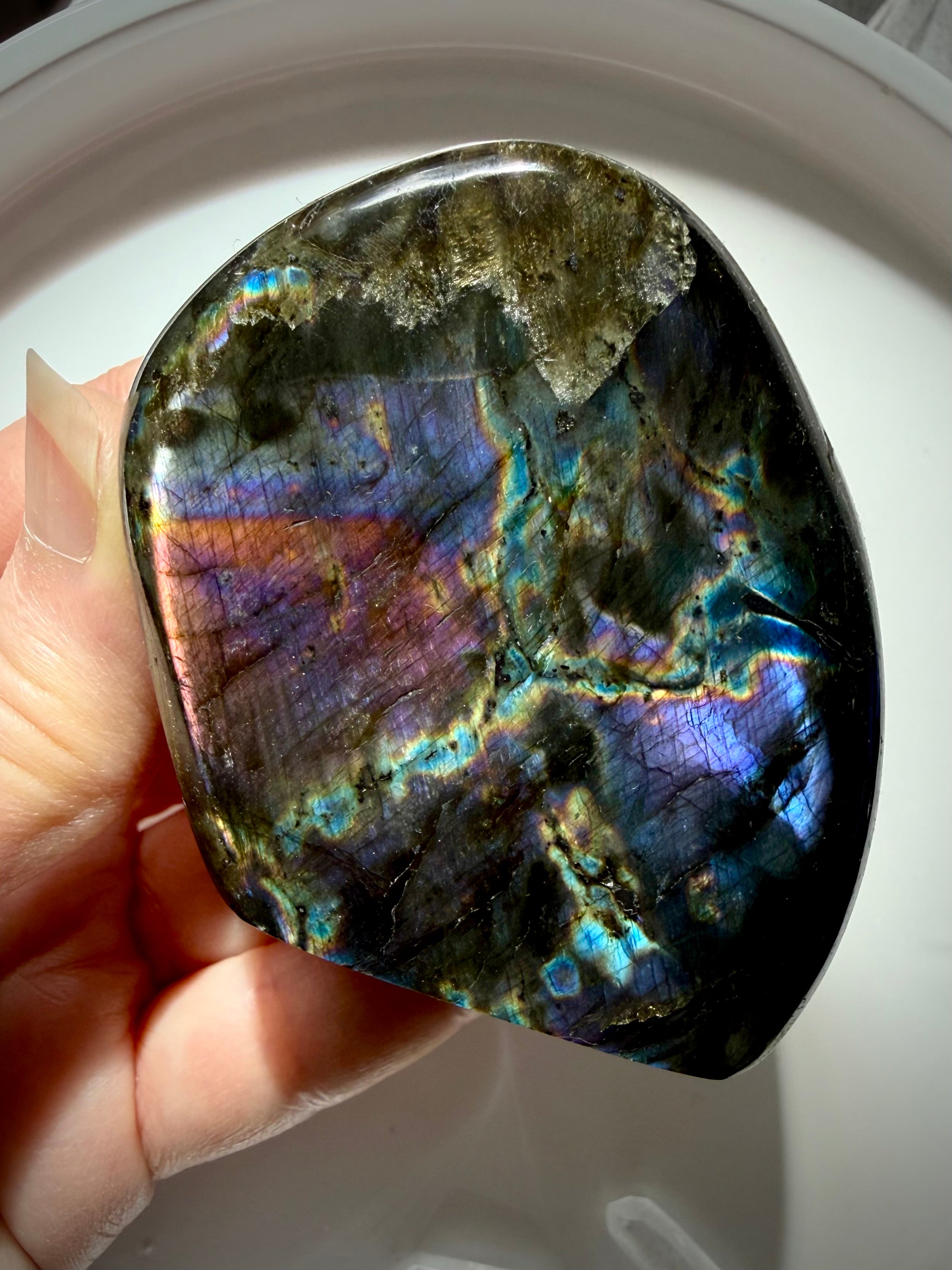 Rainbow Labradorite freeform held in hand with colorful flash for intuition, protection and transformation
