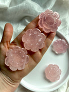 Multiple Rose Quartz lotus carvings displayed in hand, polished crystal flowers for altar decor