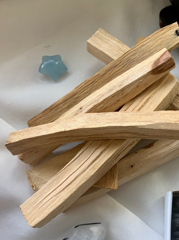 a pile of palo santo sticks with an aquamarine star