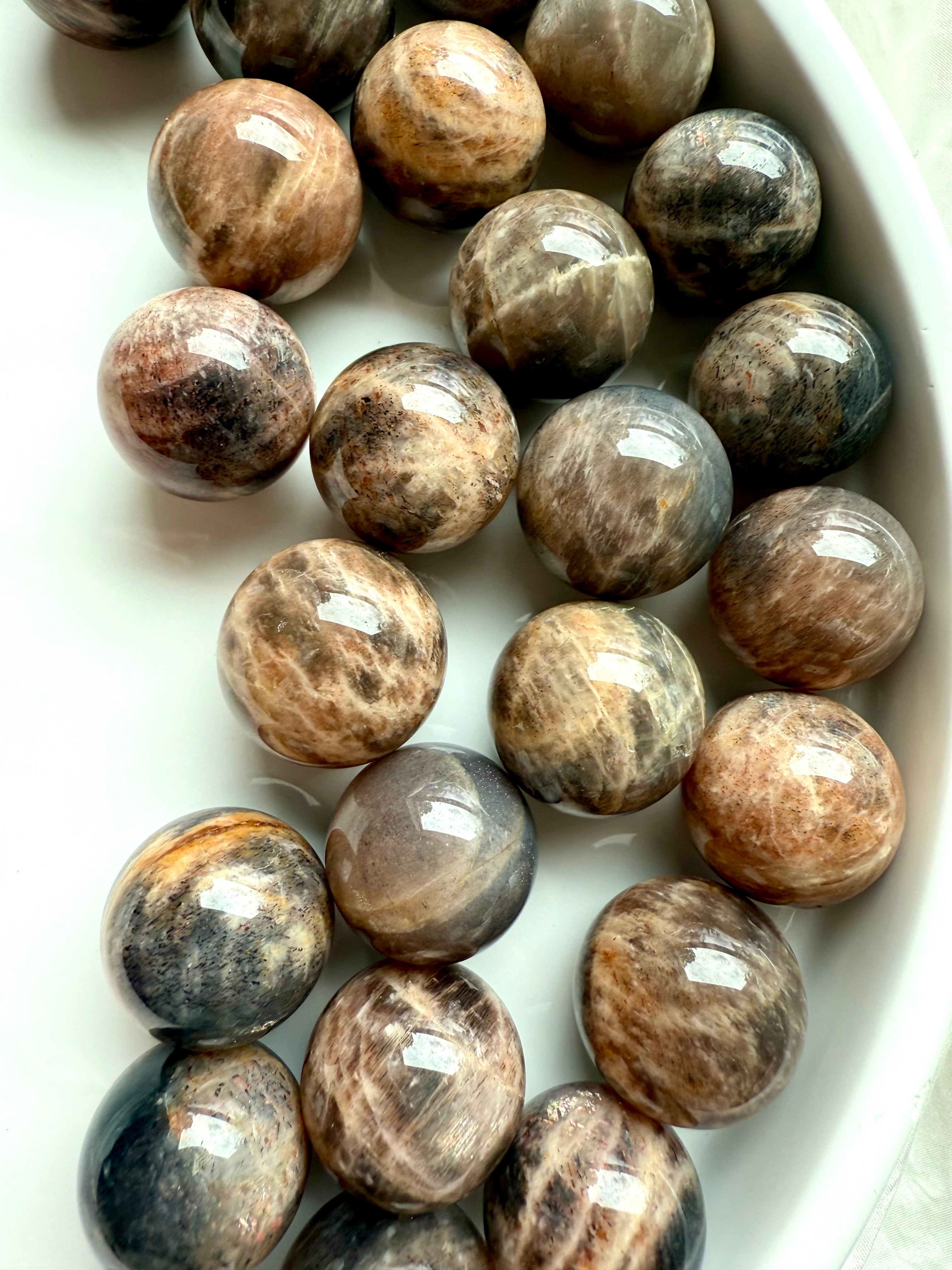 Mini Black Moonstone spheres with Sunstone shimmer arranged on white background
