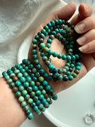 Chrysocolla Shattuckite beaded bracelets wrapped around wrist, turquoise-toned crystal jewelry for spiritual communication