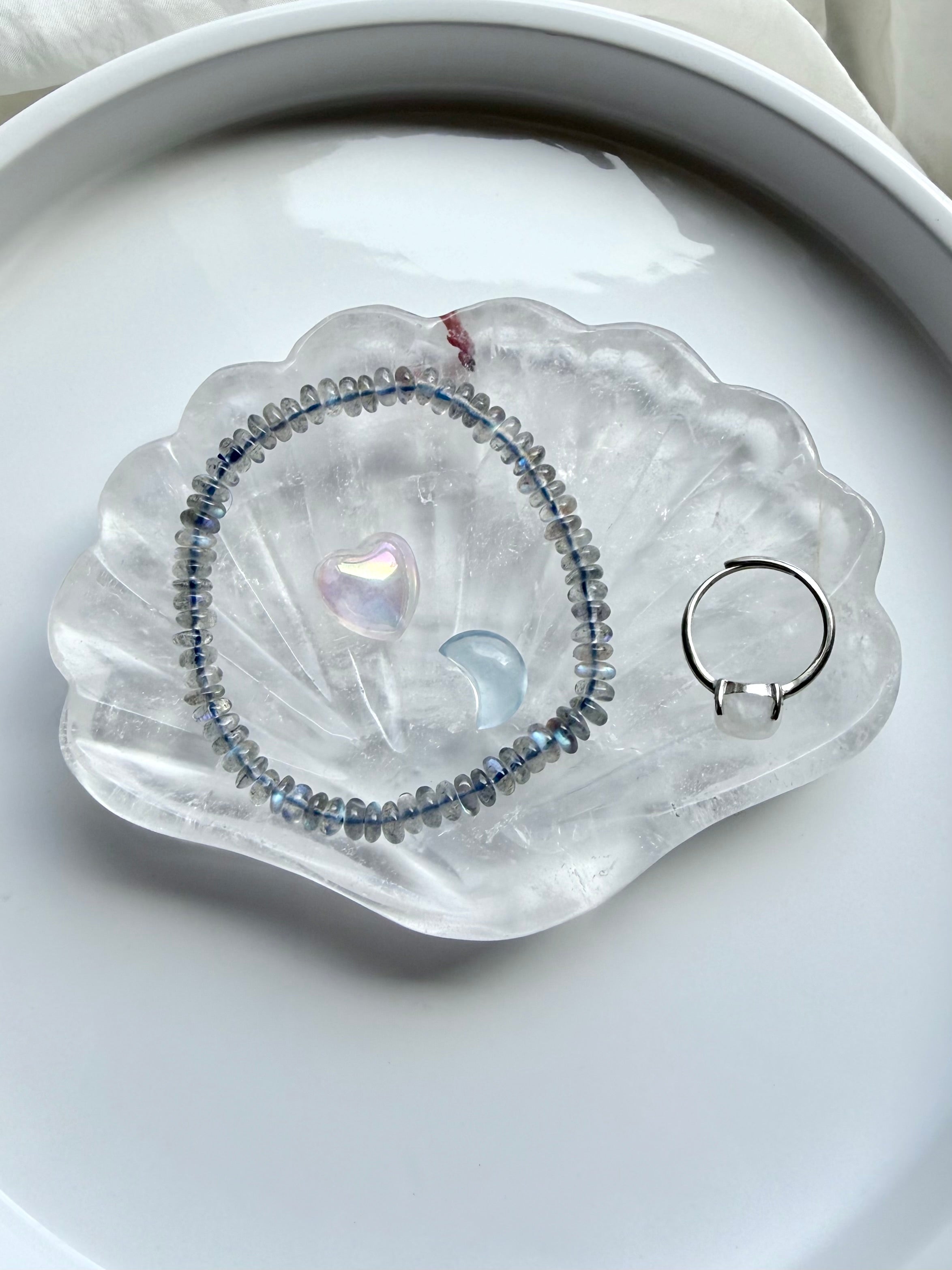 Clear Quartz scallop shell jewelry dish holding a ring and small crystal, polished gemstone bowl for jewelry storage and altar decor