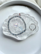 Clear Quartz scallop shell jewelry dish holding a ring and small crystal, polished gemstone bowl for jewelry storage and altar decor