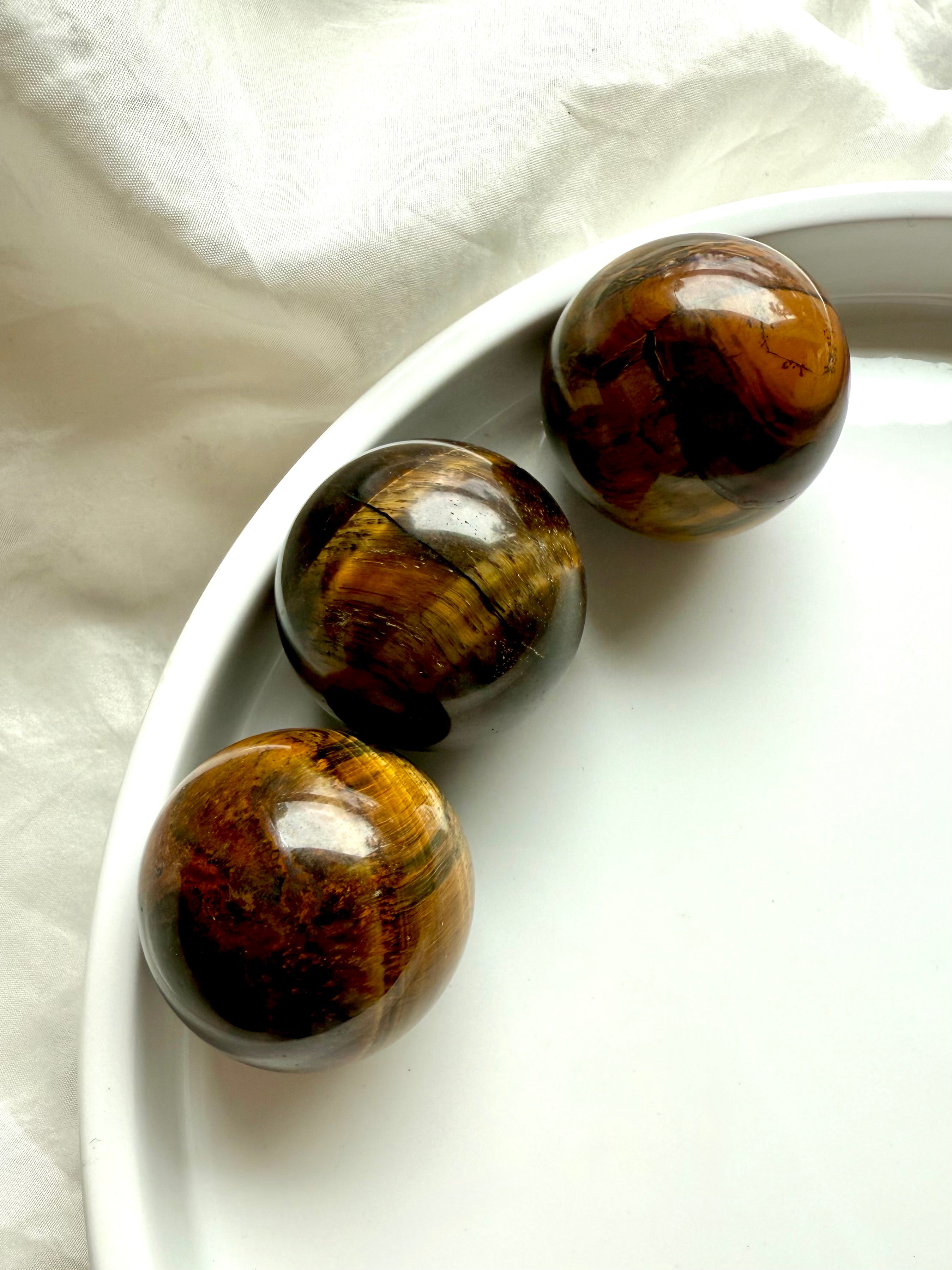 Tiger’s Eye spheres with golden brown banding: grounding crystals for protection, clarity, &amp; courage