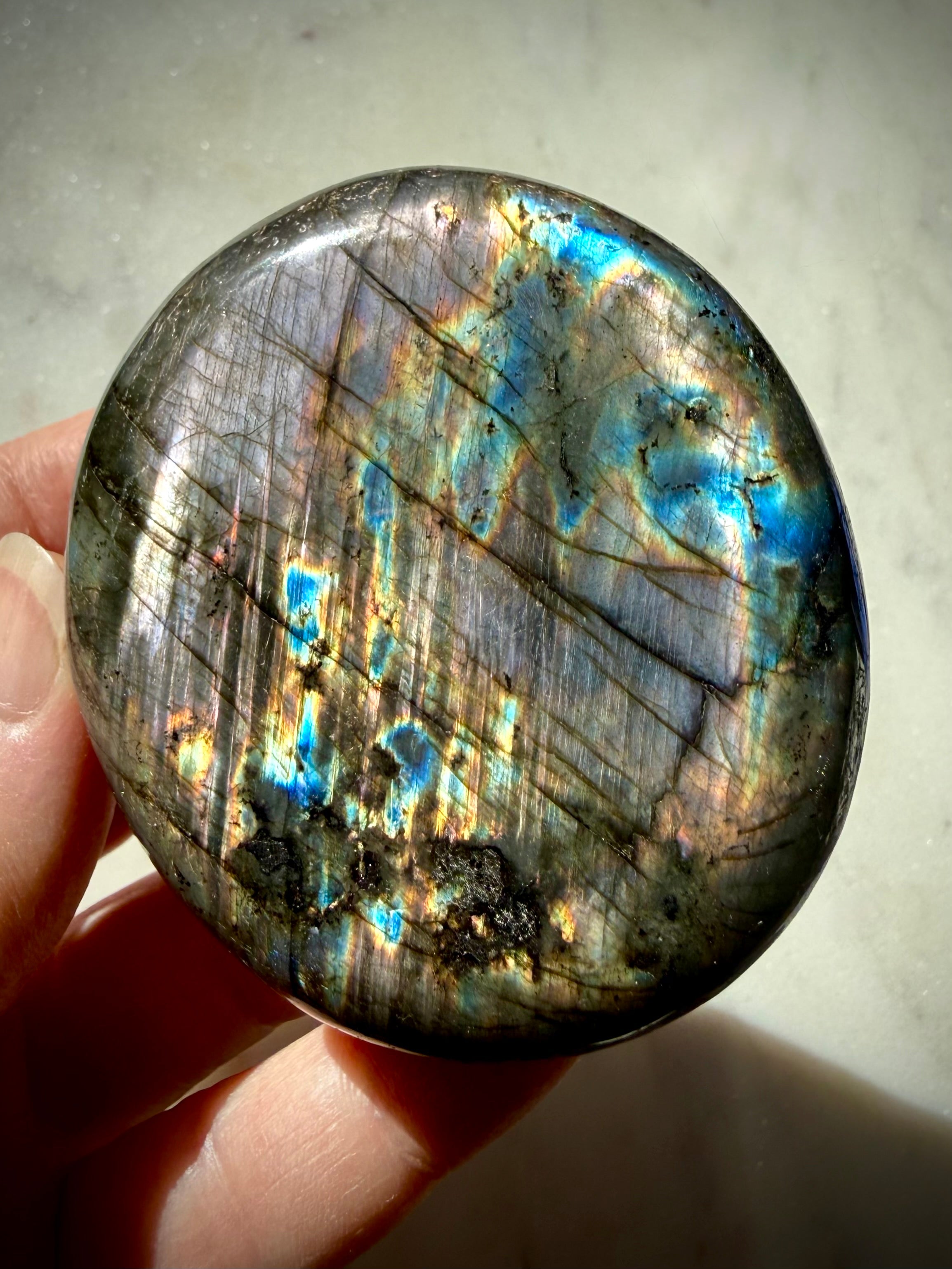 Reverse angle of Rainbow Labradorite palm stone showing aqua, blue and golden labradorescence with natural mineral patterns