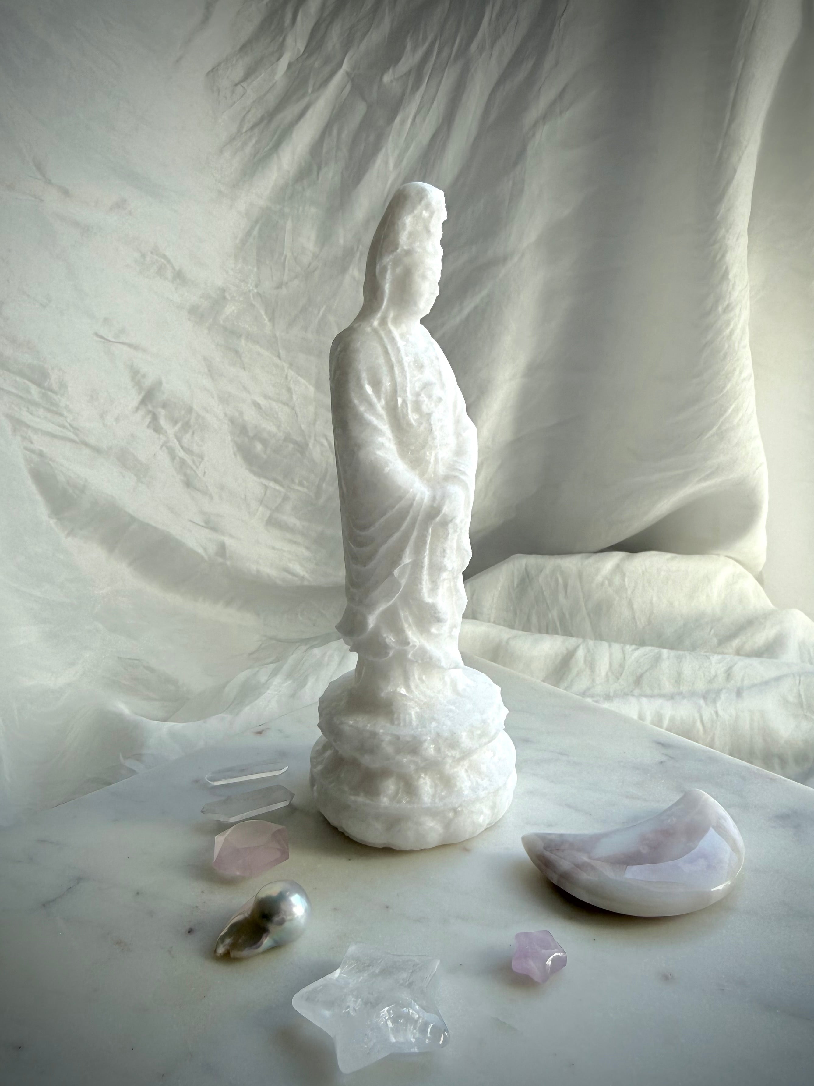 Side view of White Jade Quan Yin carving displaying graceful lines and hand-carved details