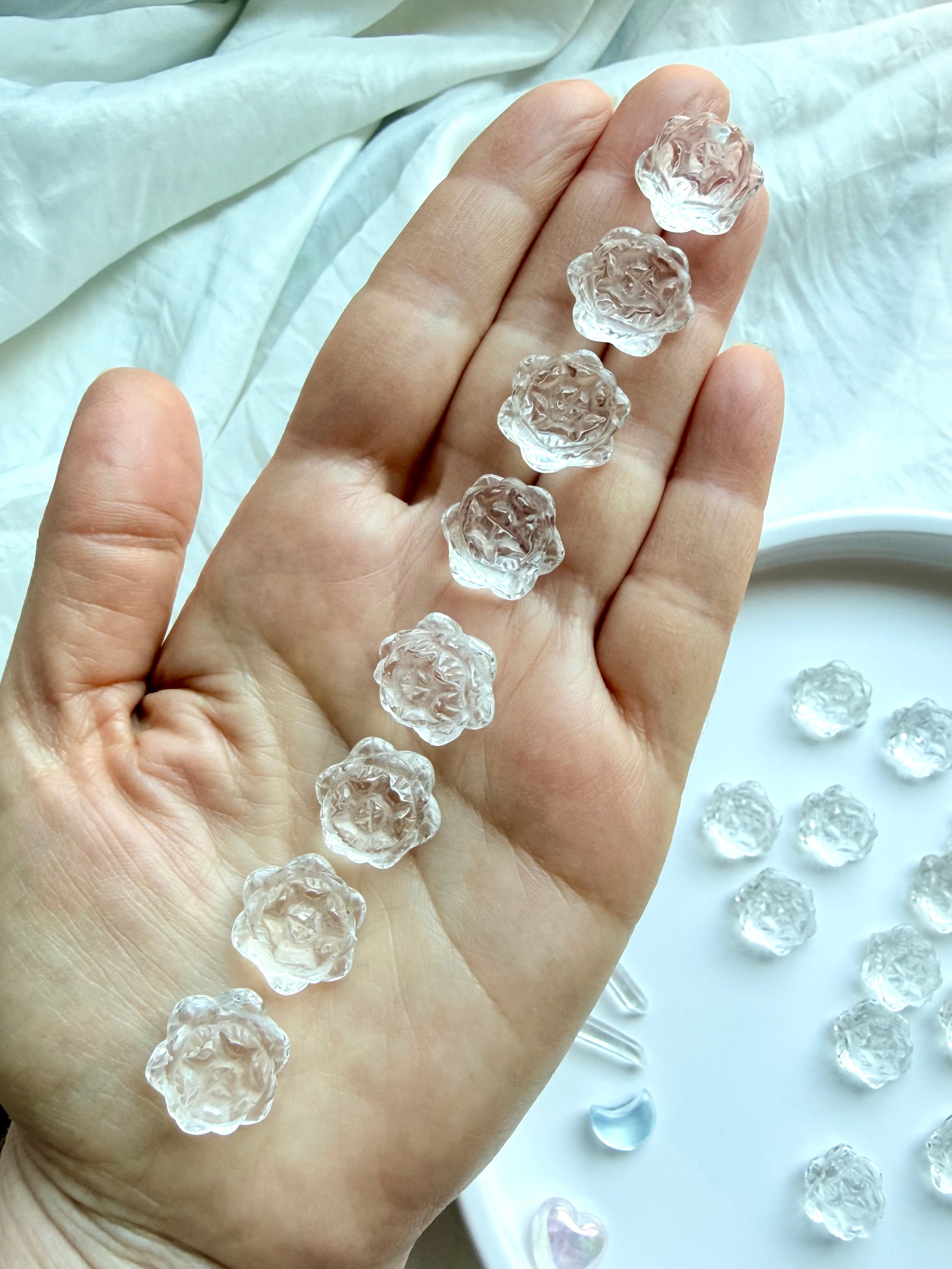 Mini Clear Quartz lotus flower carvings held in hand showing small size and natural crystal clarity