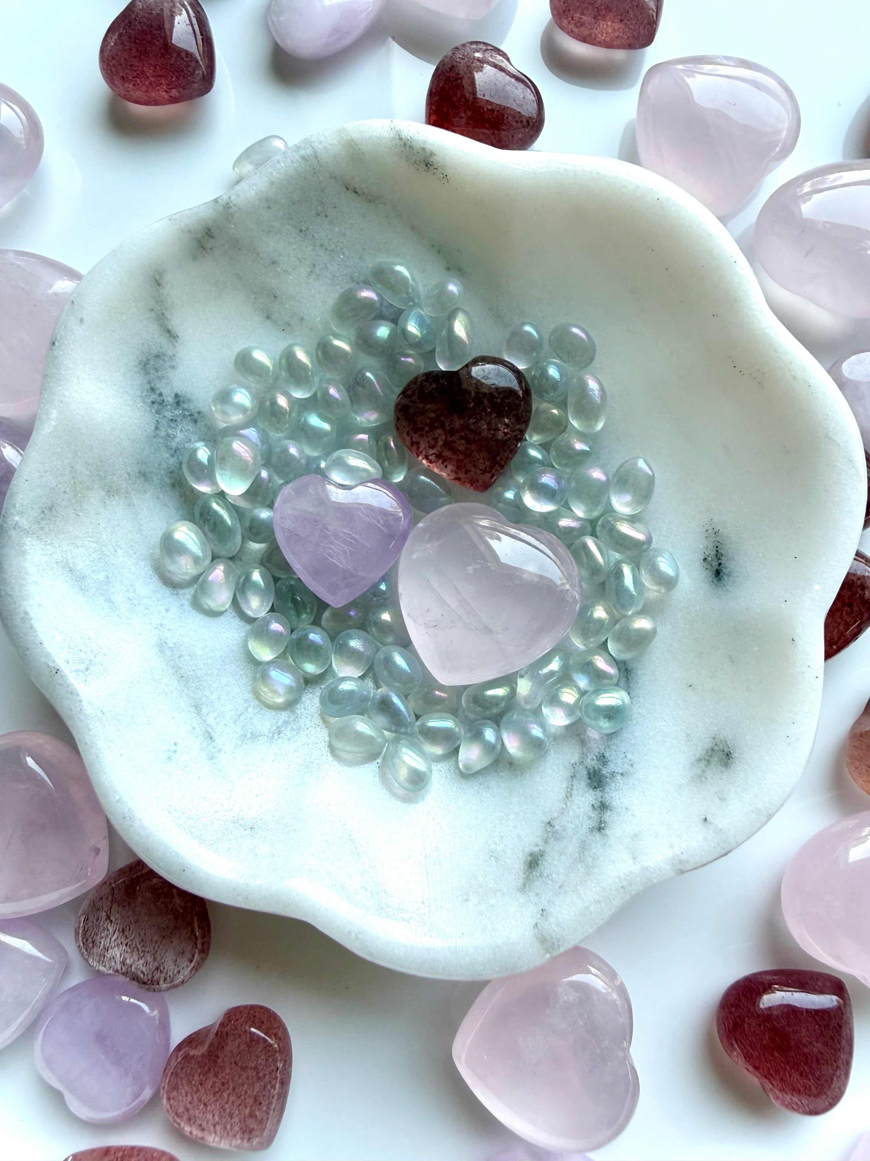 Mini crystal heart set styled in a marble bowl with rose quartz, strawberry quartz, and kunzite for altar decor or gift display