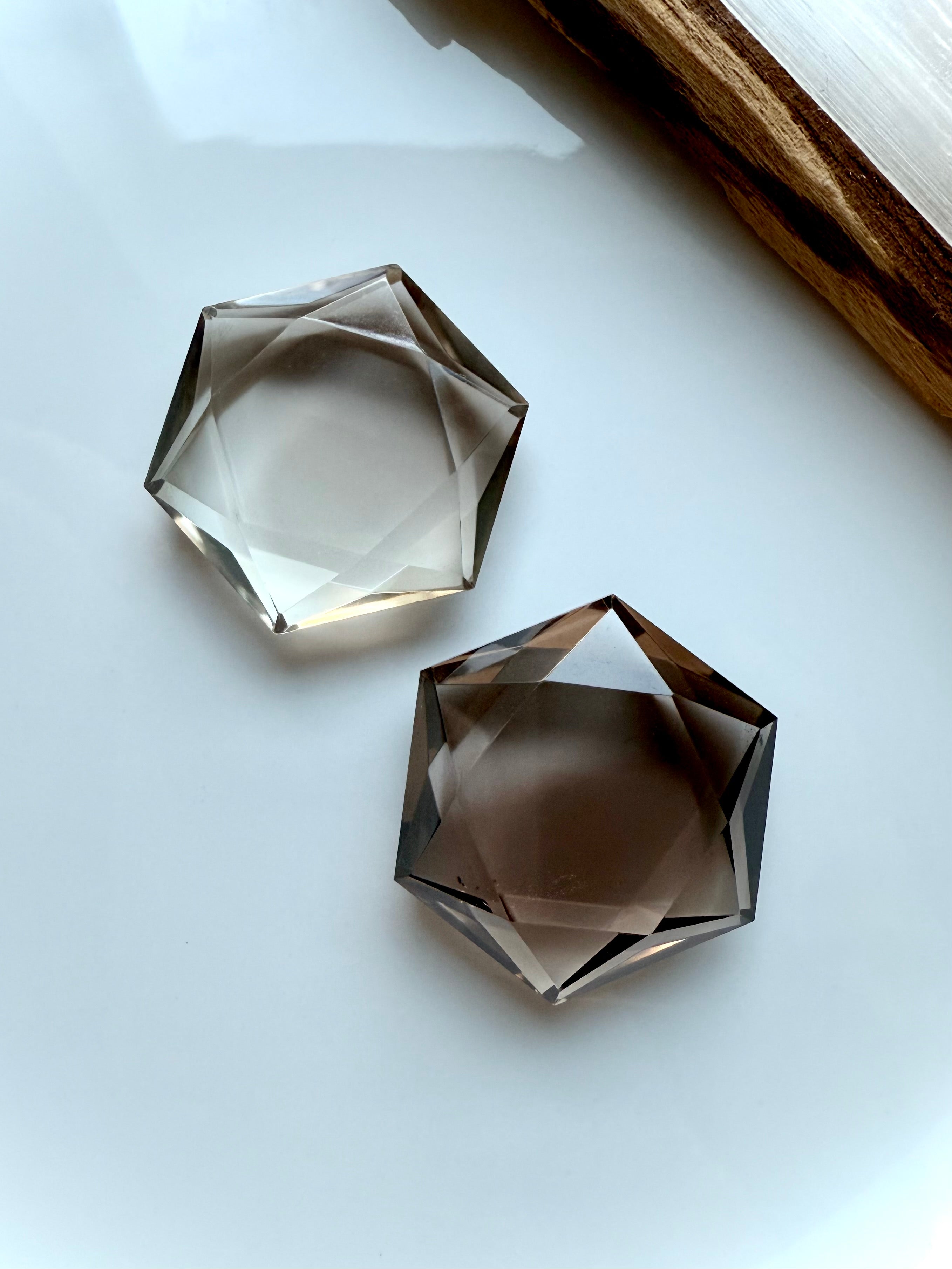 Closeup view of two smoky quartz hexagons on white showing light and dark color variation – Root Chakra crystals for ritual and energy work.