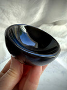 Round Black Obsidian bowl held in hand for size reference