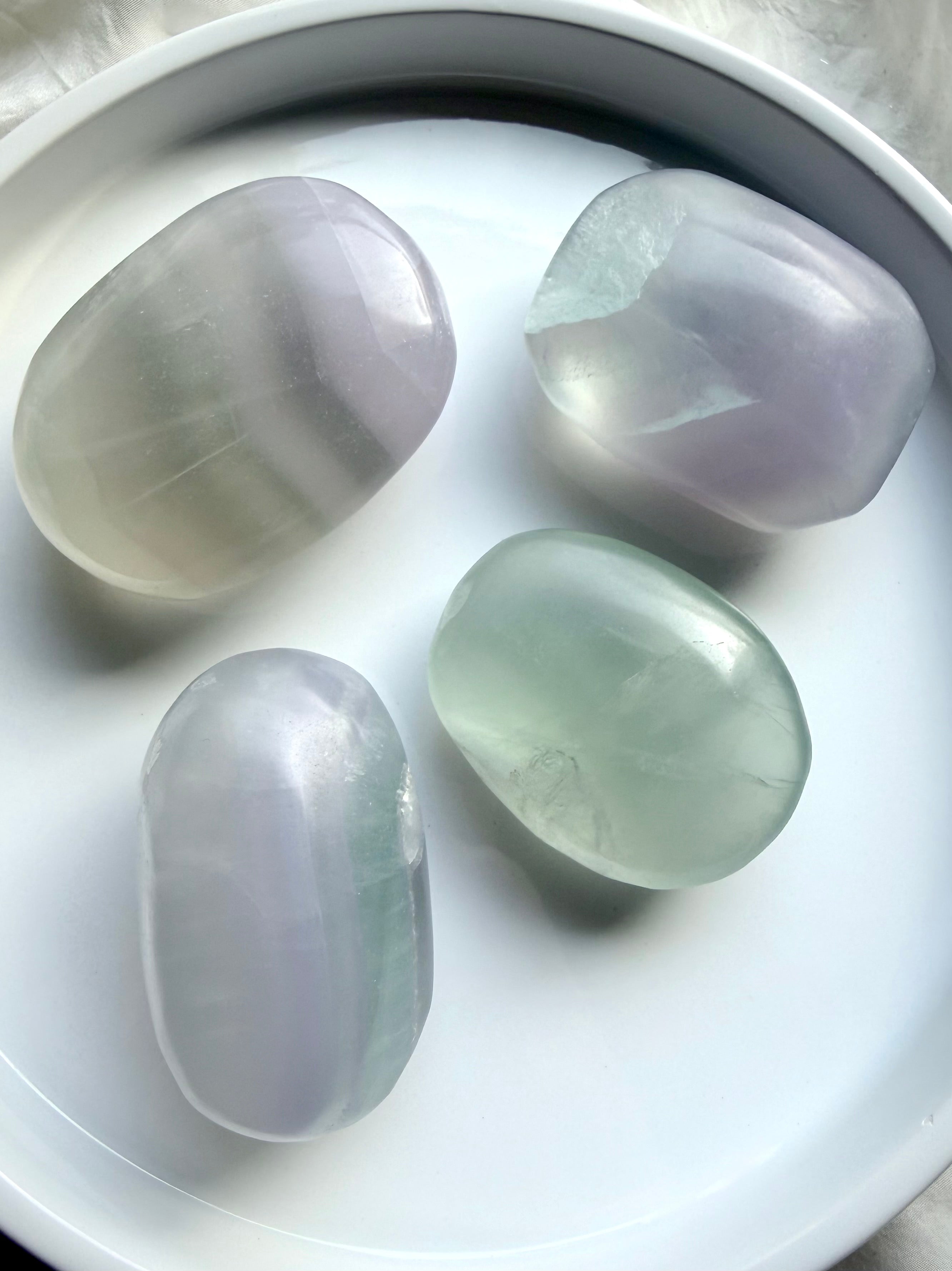 group of yttrium fluorite palm stones with mixed pastel tones and smooth polished finish
